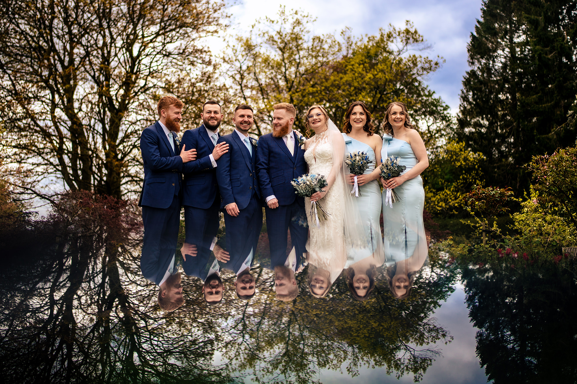 Bridesmaids and groomsmen reflected in the garden pond at Salt House, Staffordshire wedding photographer
