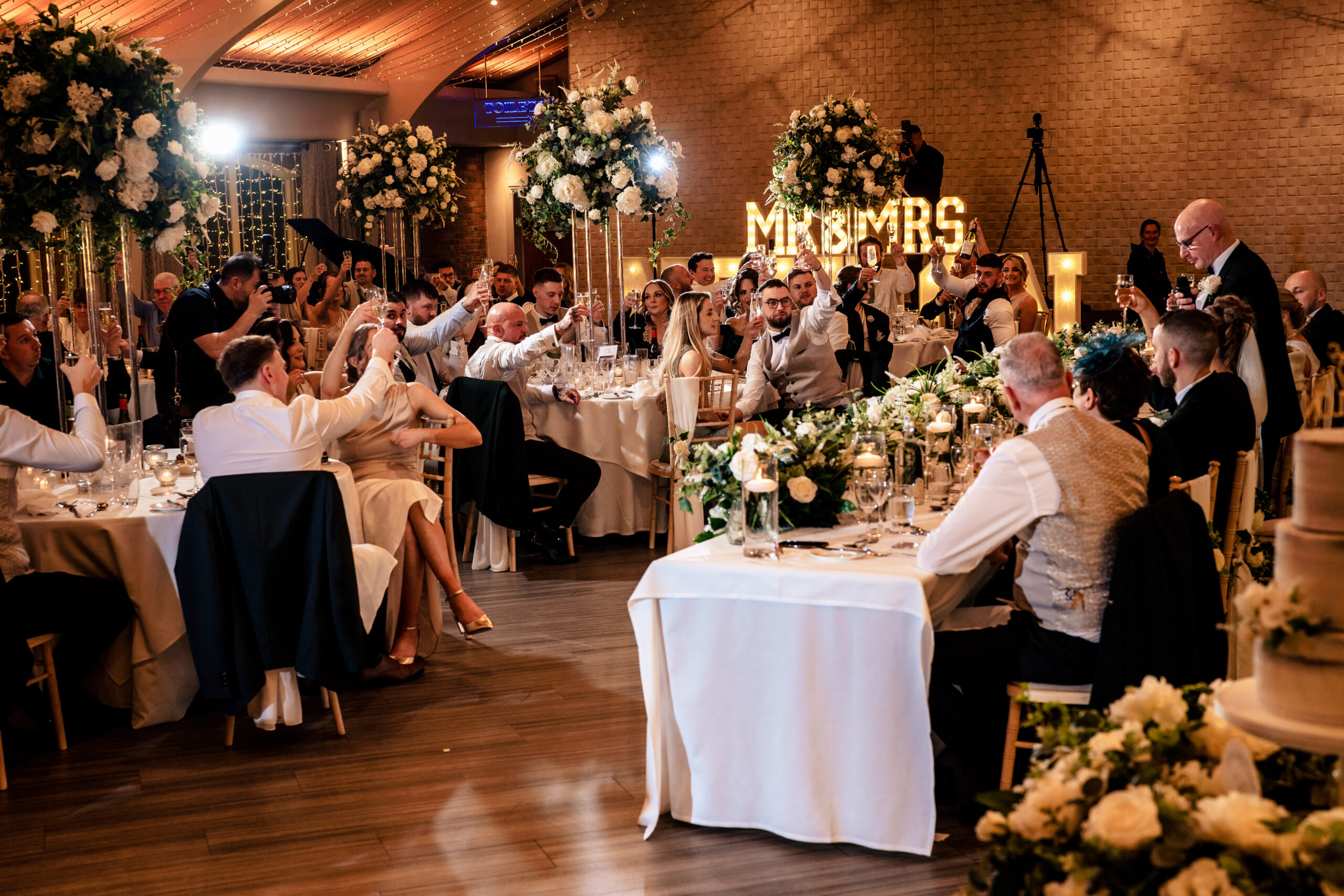 The reception room at Colshaw Hall, guests seated under the glow of the Mr and Mrs sign