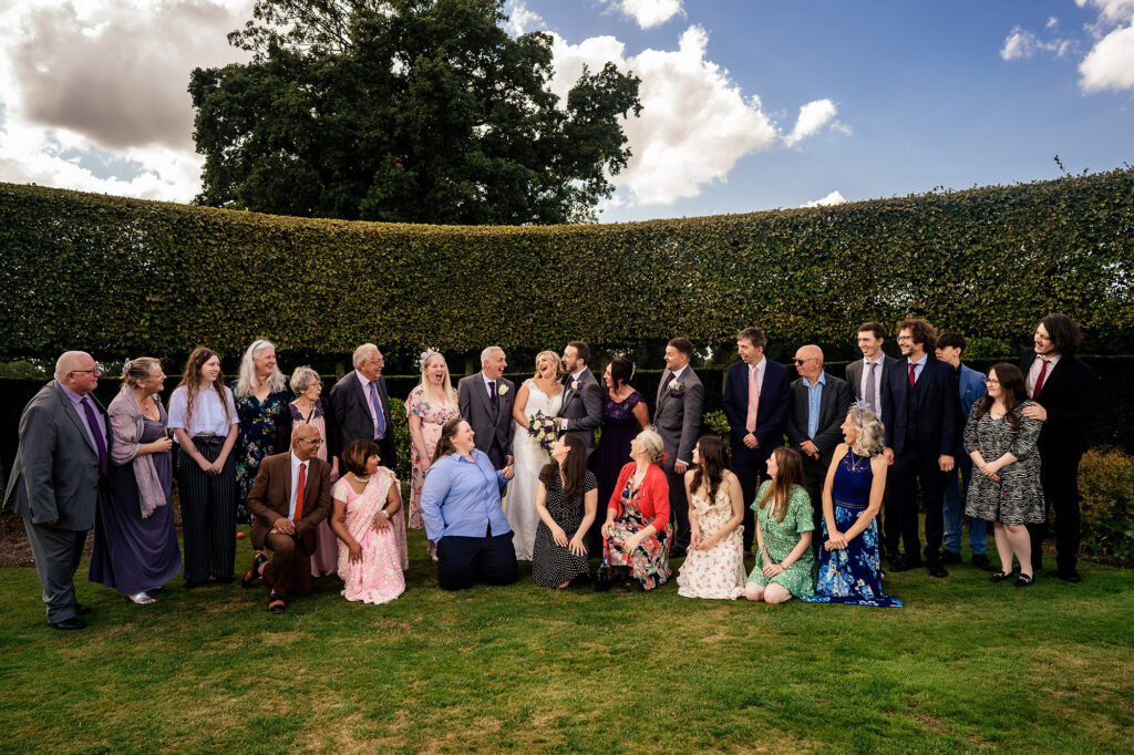 Big group photo of wedding guests in the hedged garden at Merrydale Manor, Merrydale Manor wedding photographer