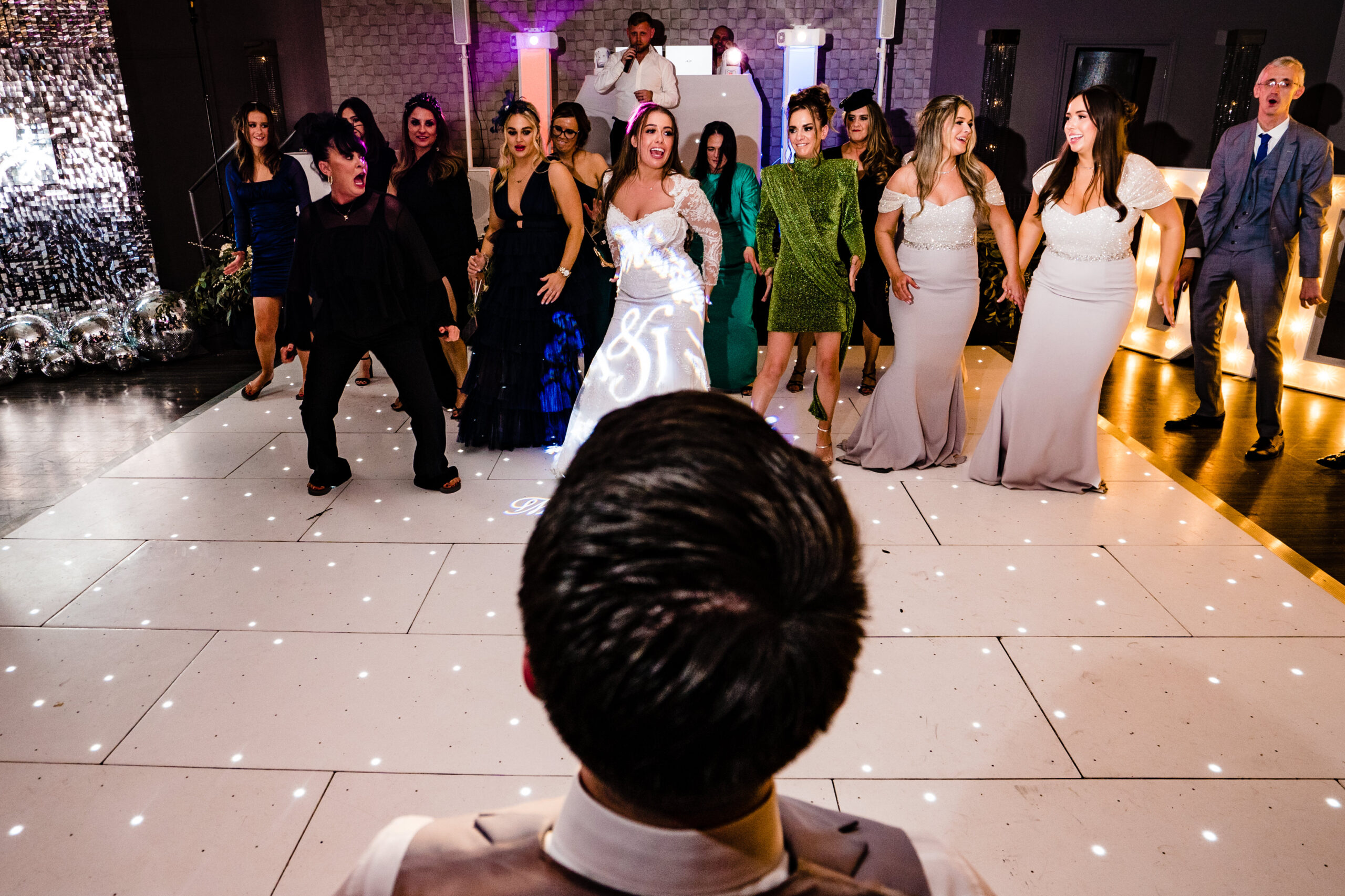 Abbie and her bridesmaids dancing for Jamie as he watches from his chair at Merrydale Manor