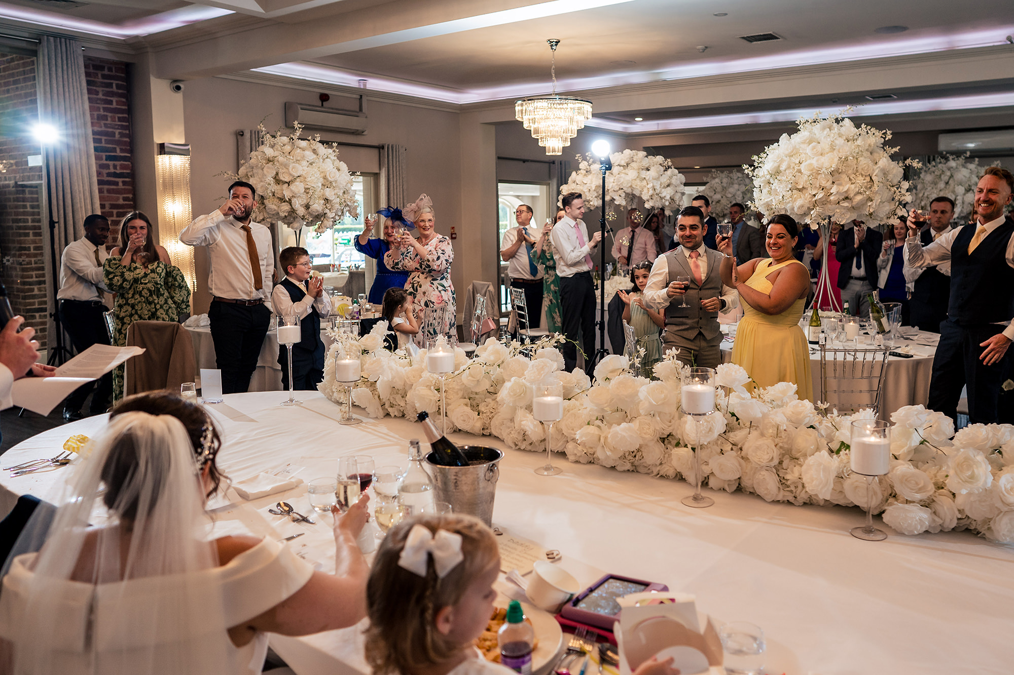 A flower girl distracted by something sweet at the dinner table, Merrydale Manor wedding photographer