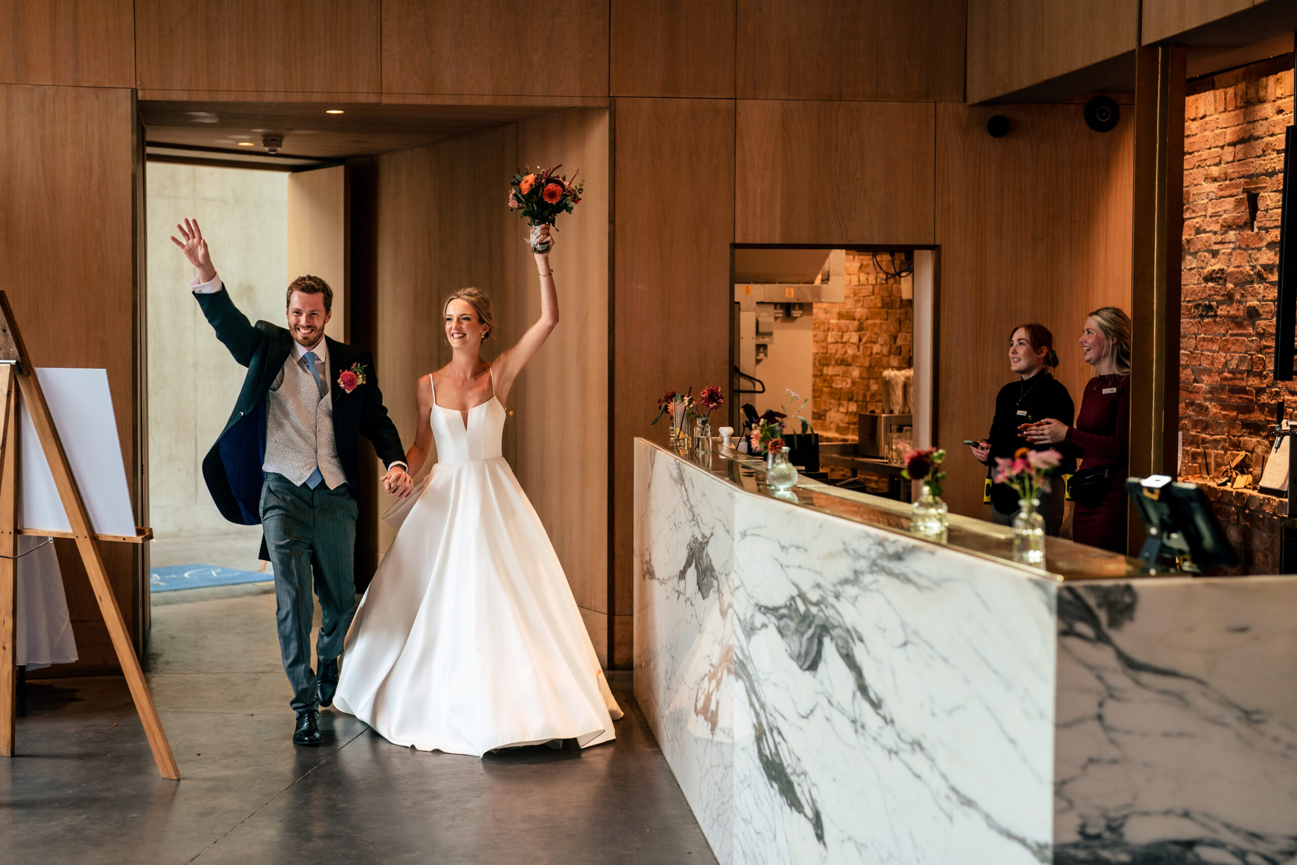 Bride and groom throwing their arms in the air as they are announced into the reception at Dorfold Hall