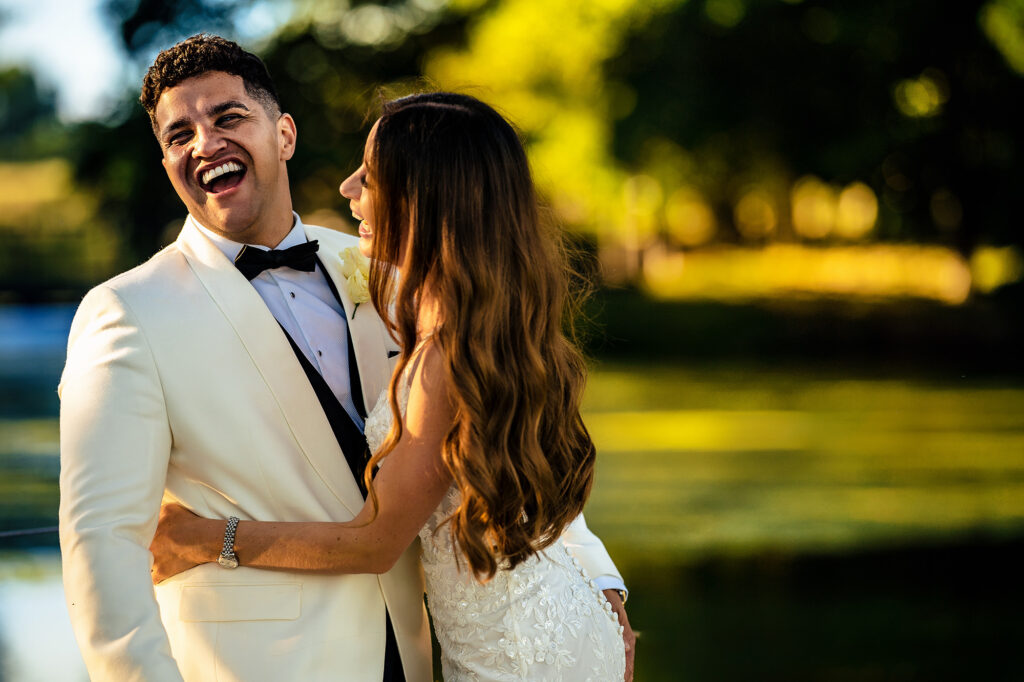 Tyrone laughing with his head thrown back as Gemma hugs him in the evening sun at Merrydale Manor
