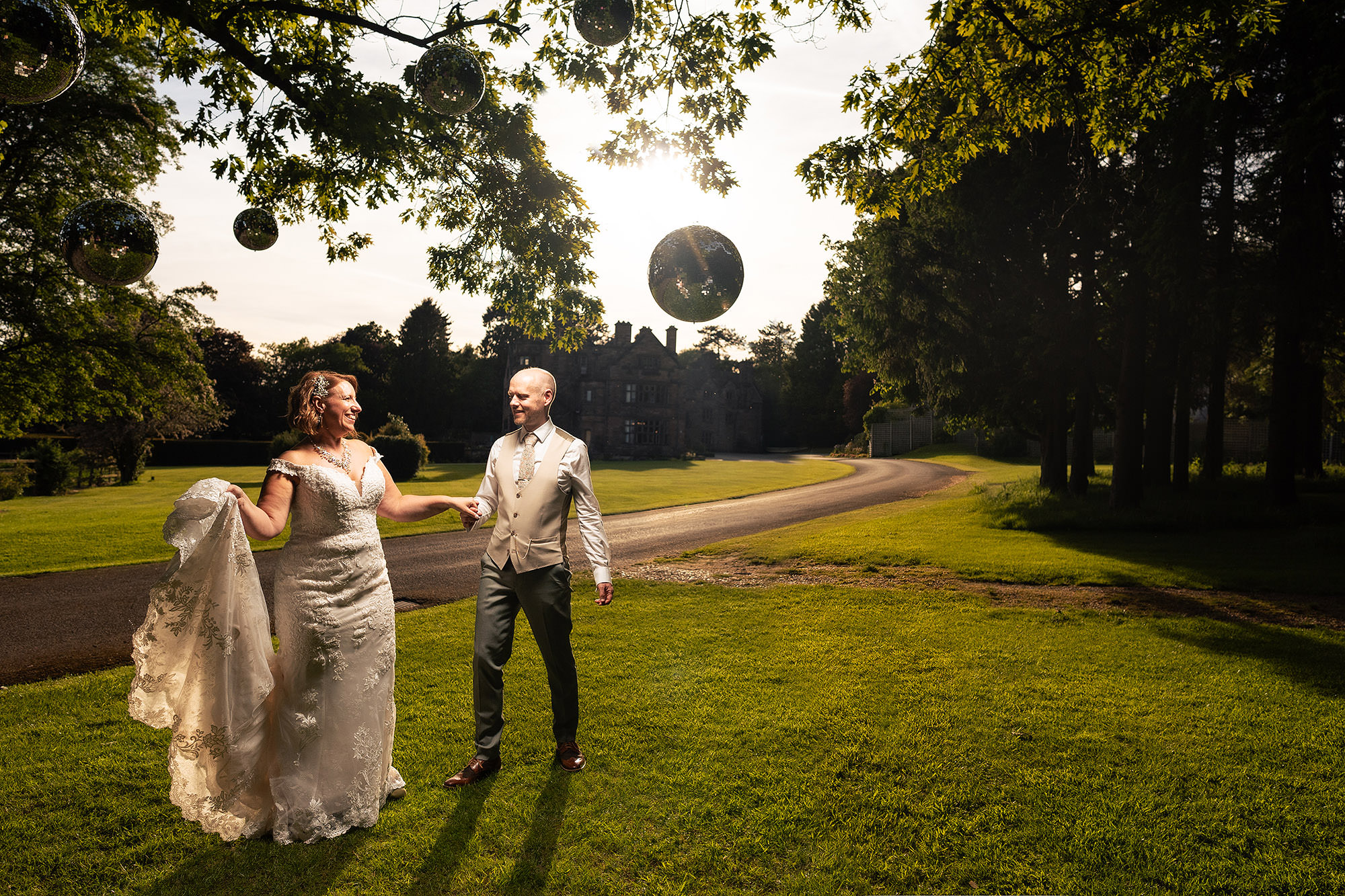 Bride and groom walking hand in hand beneath fairy lights in the grounds of Salt House at dusk