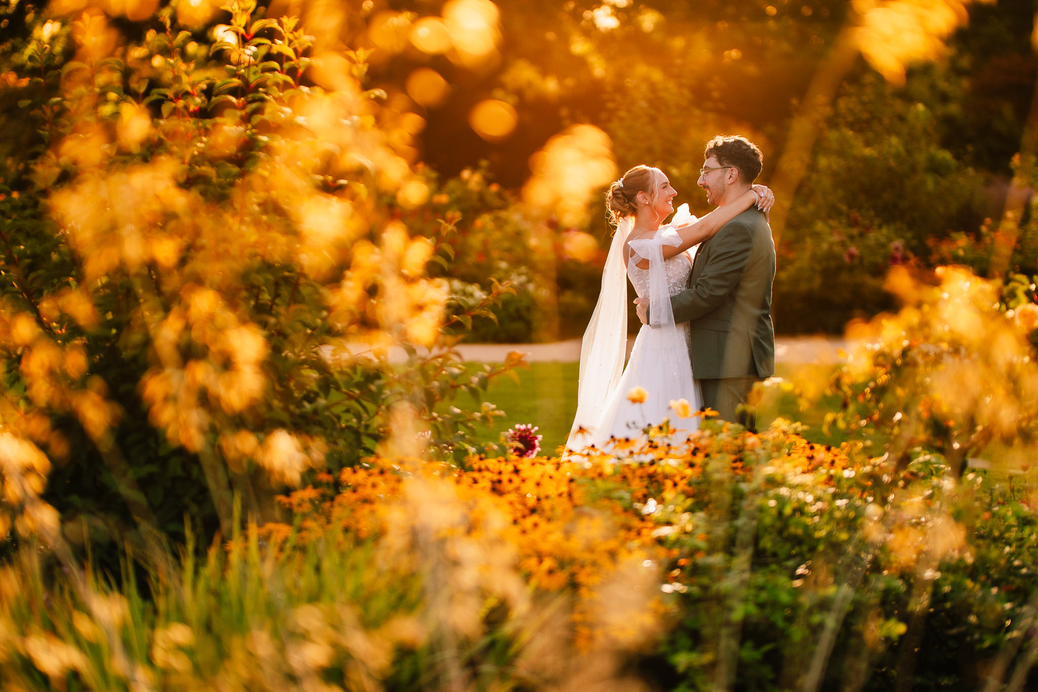 The newlyweds embracing in warm golden hour light in the gardens at Salt House