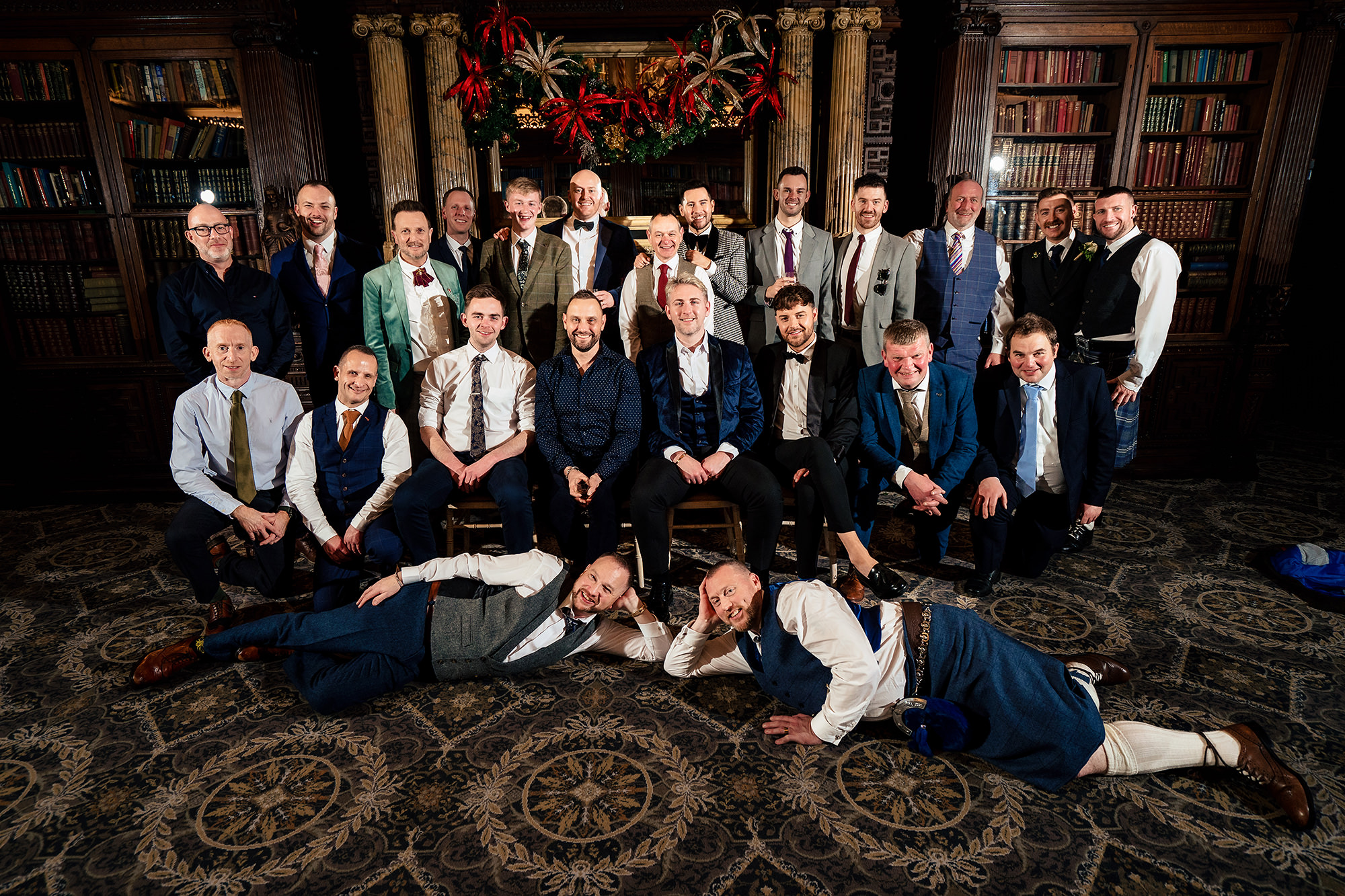 A playful, everyone-collapsed group photo in the library at Crewe Hall