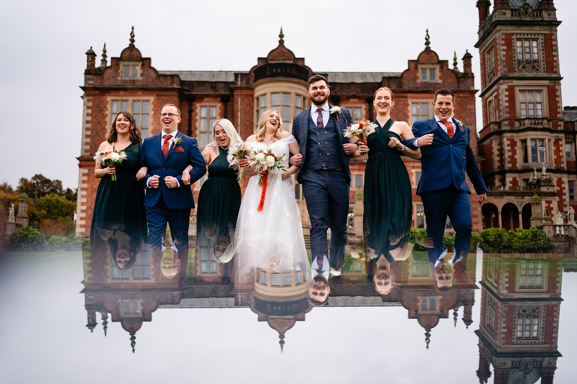 A creative mirror reflection portrait of the wedding party in front of Crewe Hall, Cheshire wedding photographer