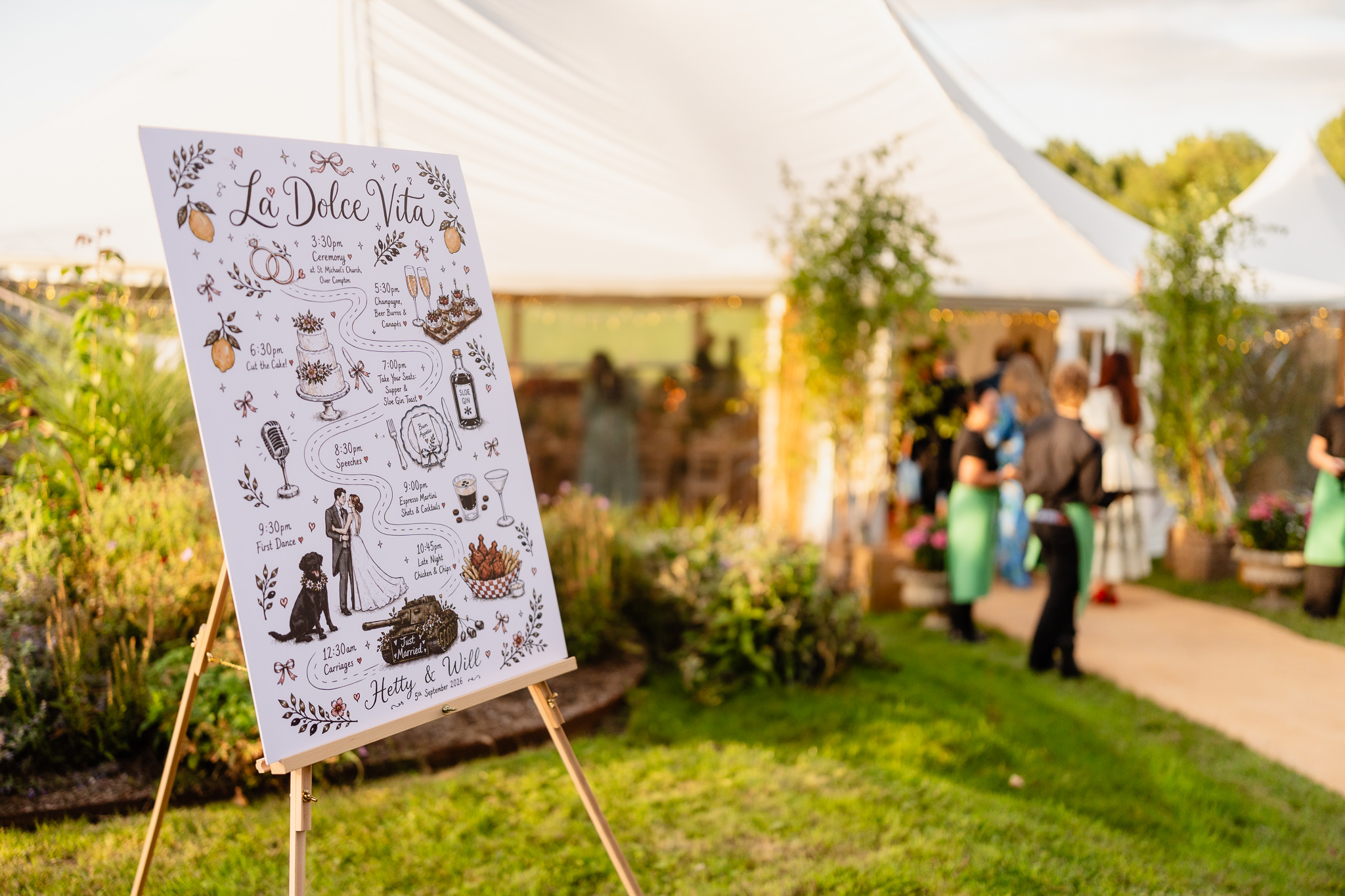 Hand drawn wedding welcome sign on an easel outside the marquee