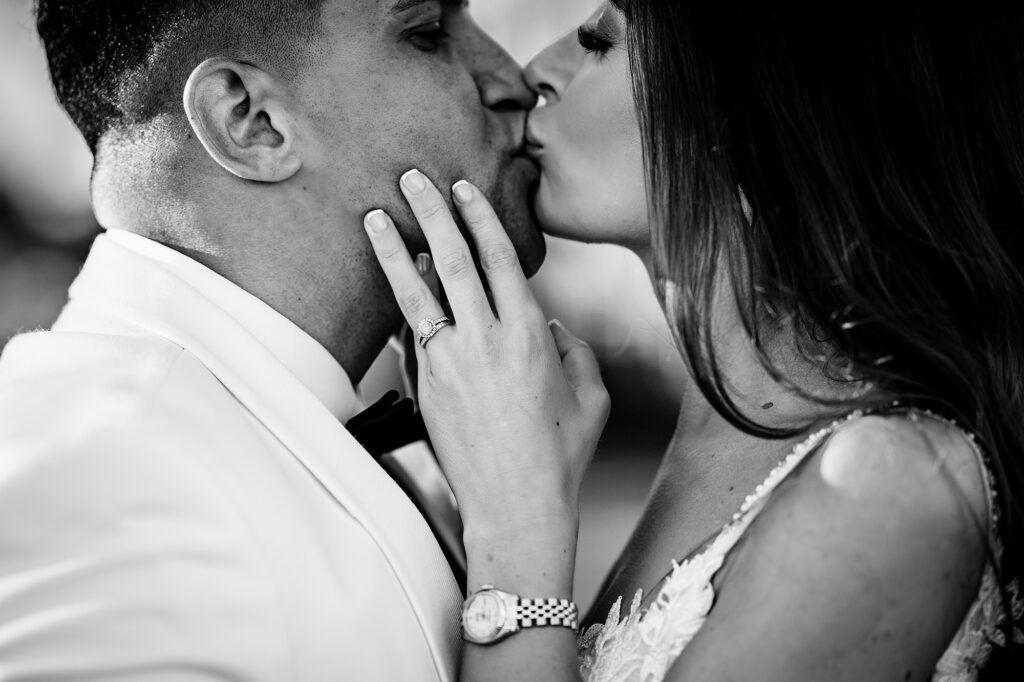 Black and white close up of Gemma kissing Tyrone, her rings on show