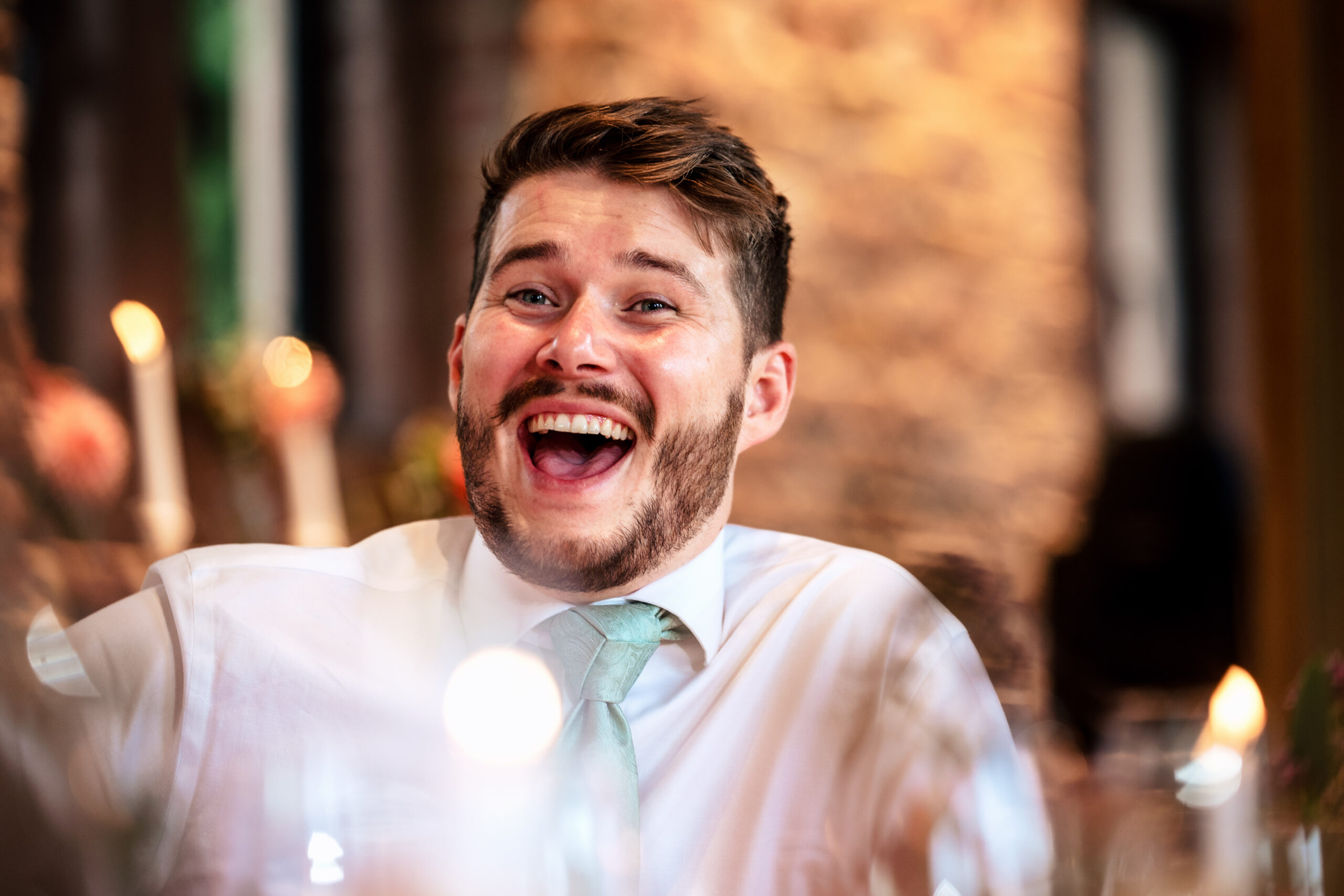 Guest thrown into laughter by a line in the speeches at Dorfold Hall, Cheshire wedding photographer