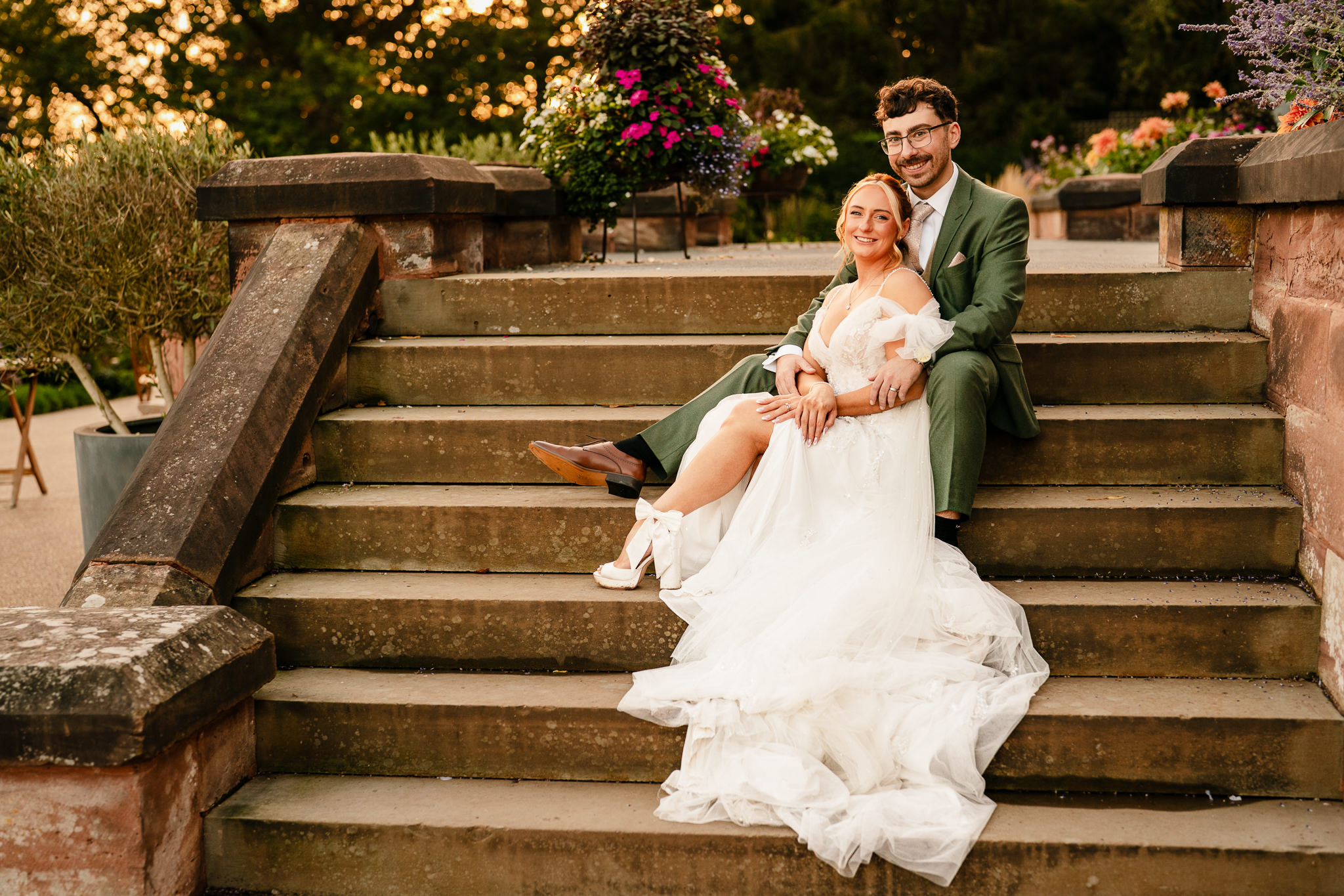 Bride and groom laughing together on the stone steps at Salt House during golden hour