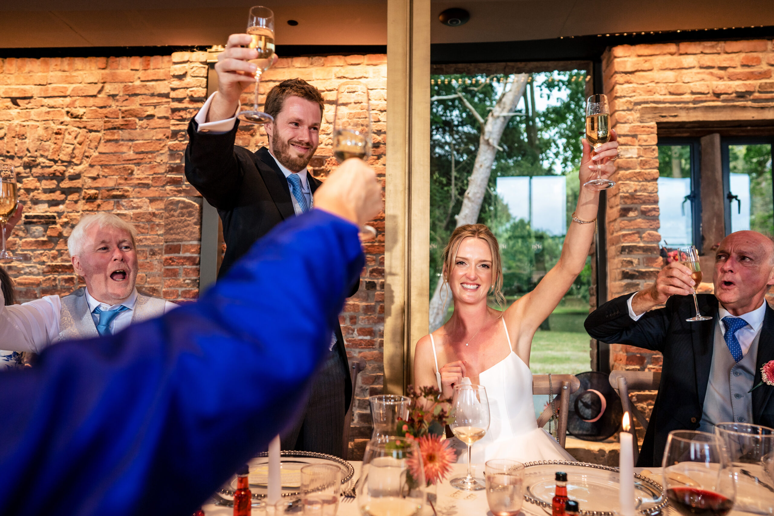 Top table raising a toast to the newlyweds during the speeches at Dorfold Hall