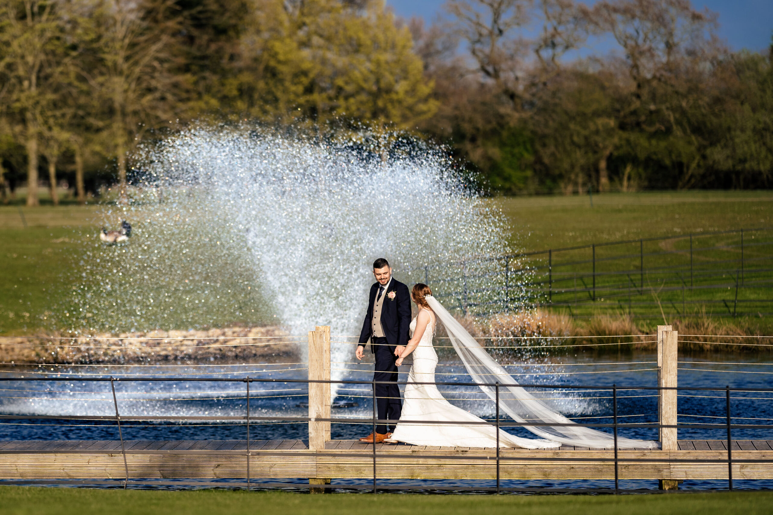 Dean and Bethany on the wooden jetty in front of the lake fountain at Merrydale Manor