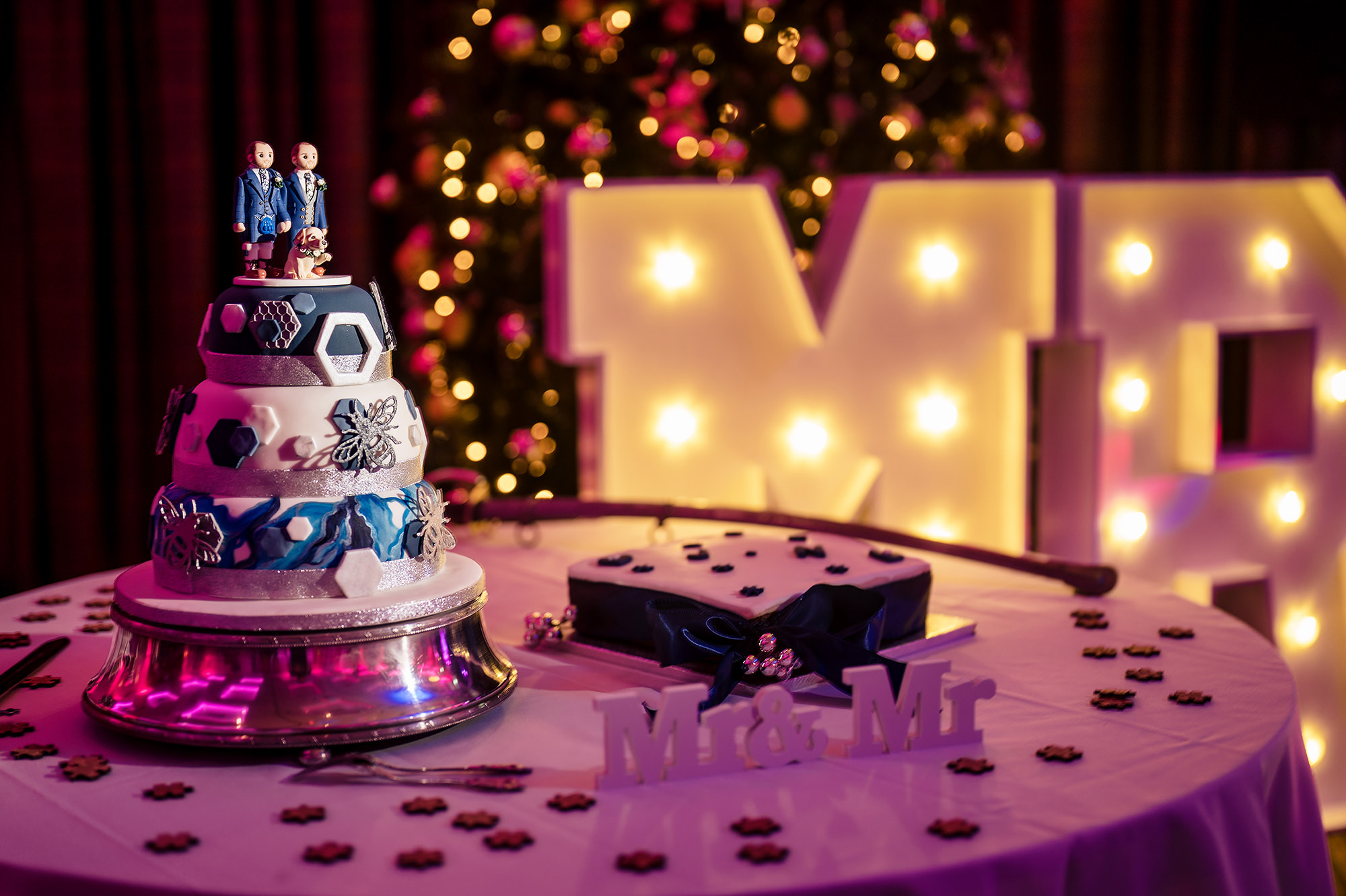 The wedding cake alongside light up Mr and Mr letters at the evening reception