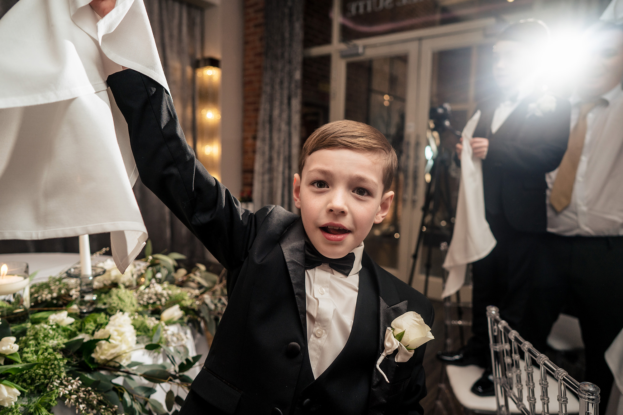 A young guest twirling his napkin over his head before the speeches at Merrydale Manor
