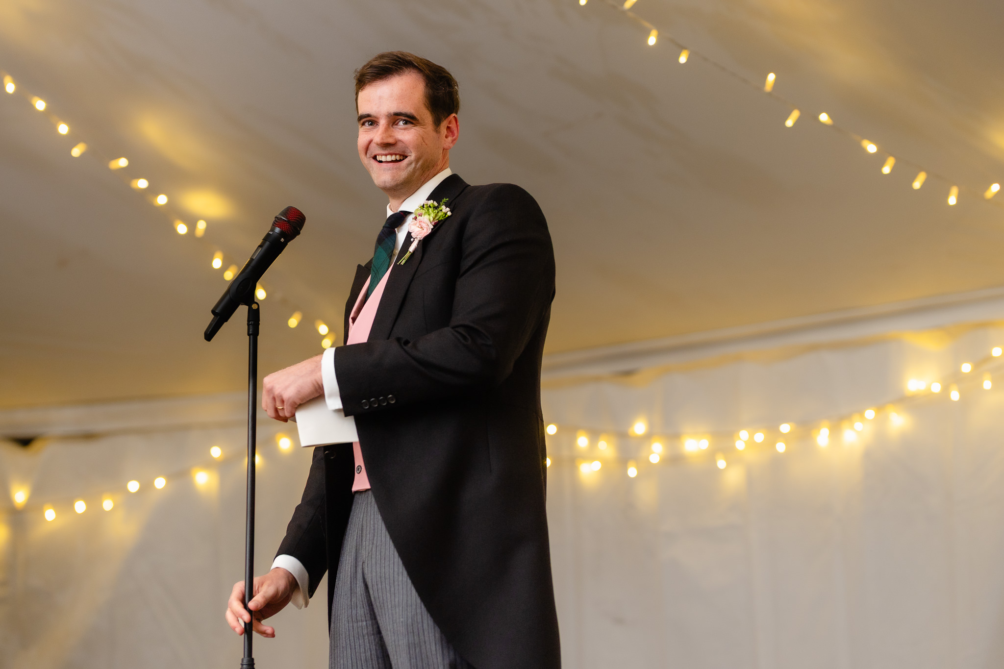 Groom giving his speech under the fairy lights in the marquee