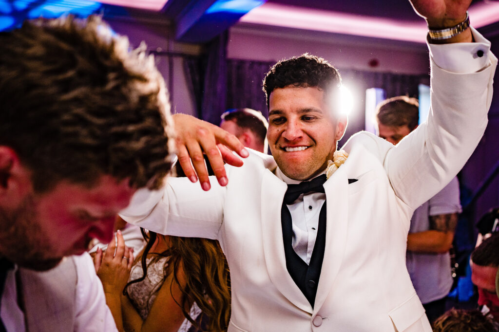 Tyrone dancing with his arms in the air on a packed dance floor at Merrydale Manor