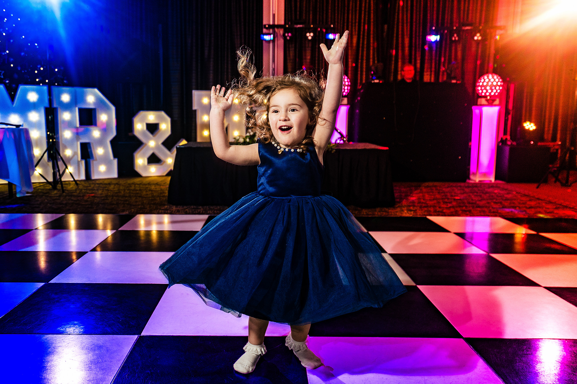 The flower girl showing off her moves on the checkerboard dance floor