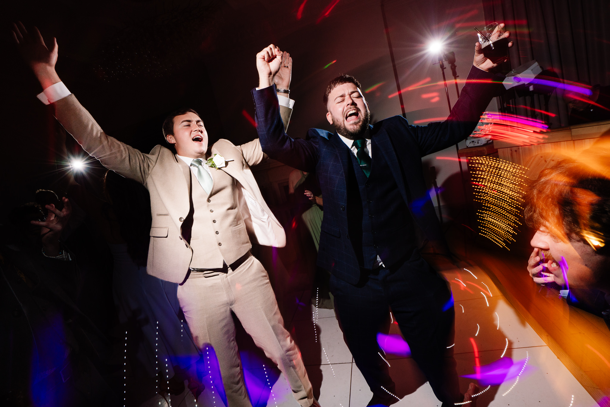 Guests dancing under colourful lights on the evening dance floor at Salt House