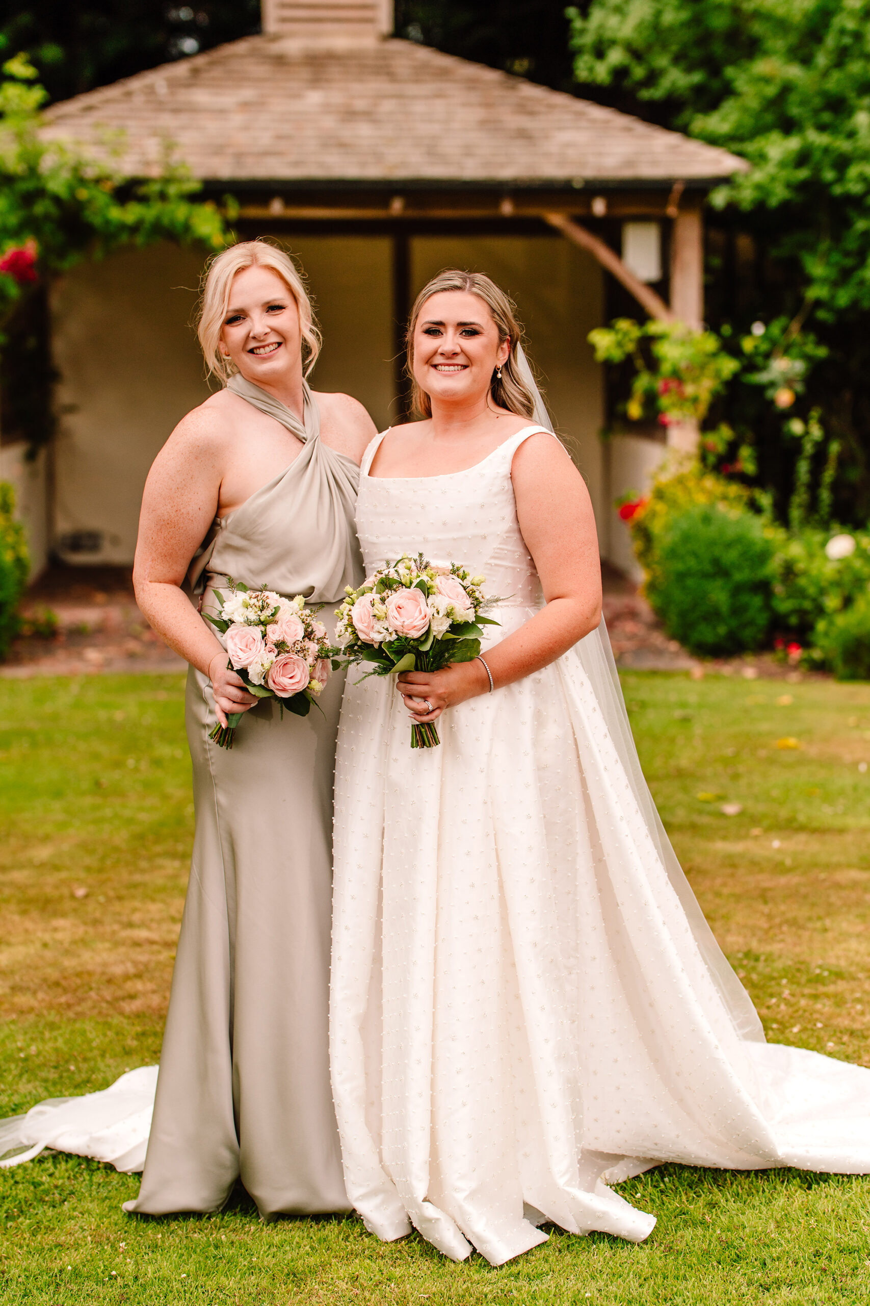 A relaxed portrait of two bridesmaids in the Wrenbury Hall gardens