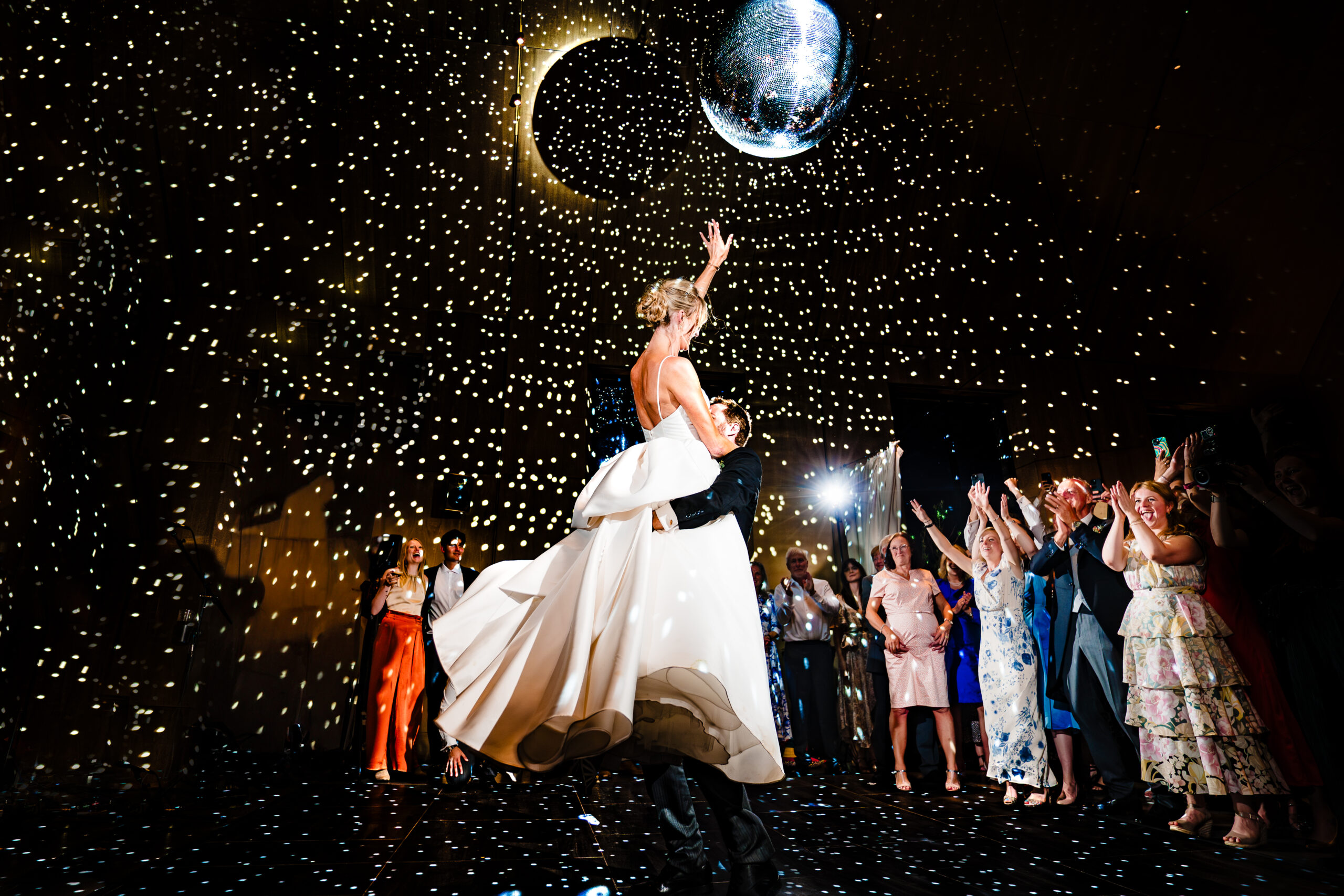 Bride and groom dancing under a disco ball and a canopy of fairy lights during their first dance at Dorfold Hall