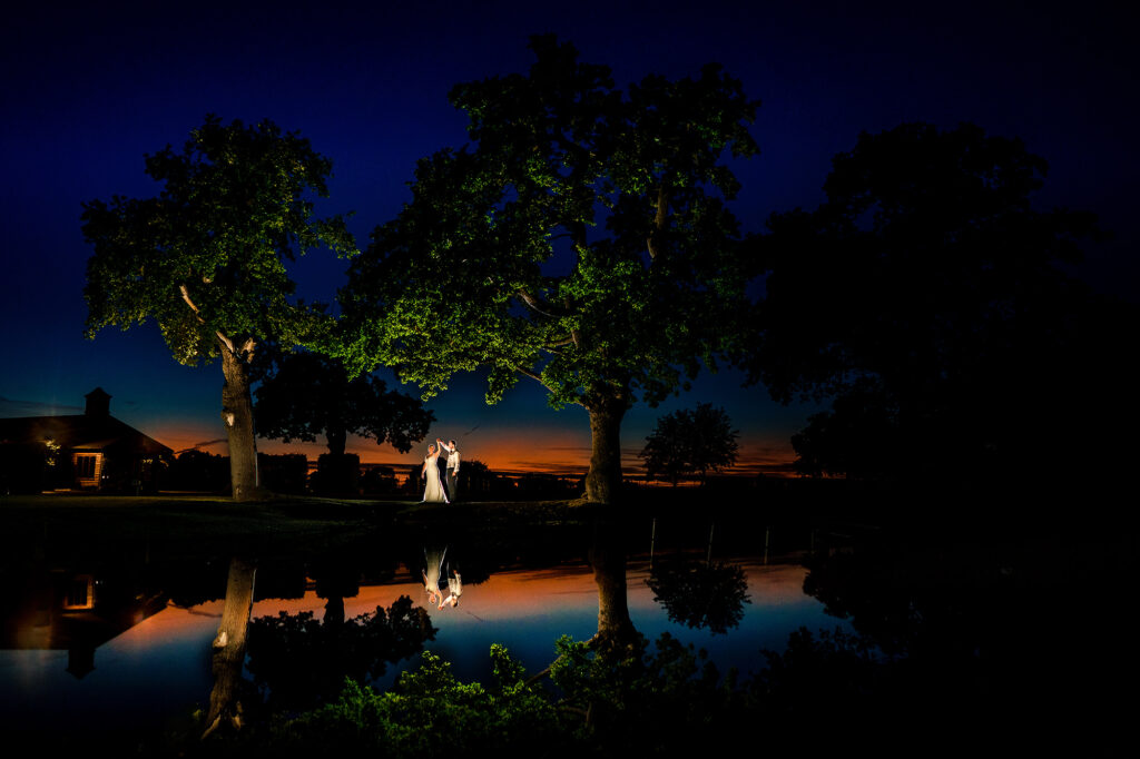Bride and groom under the trees by the lake at dusk, Merrydale Manor wedding photographer