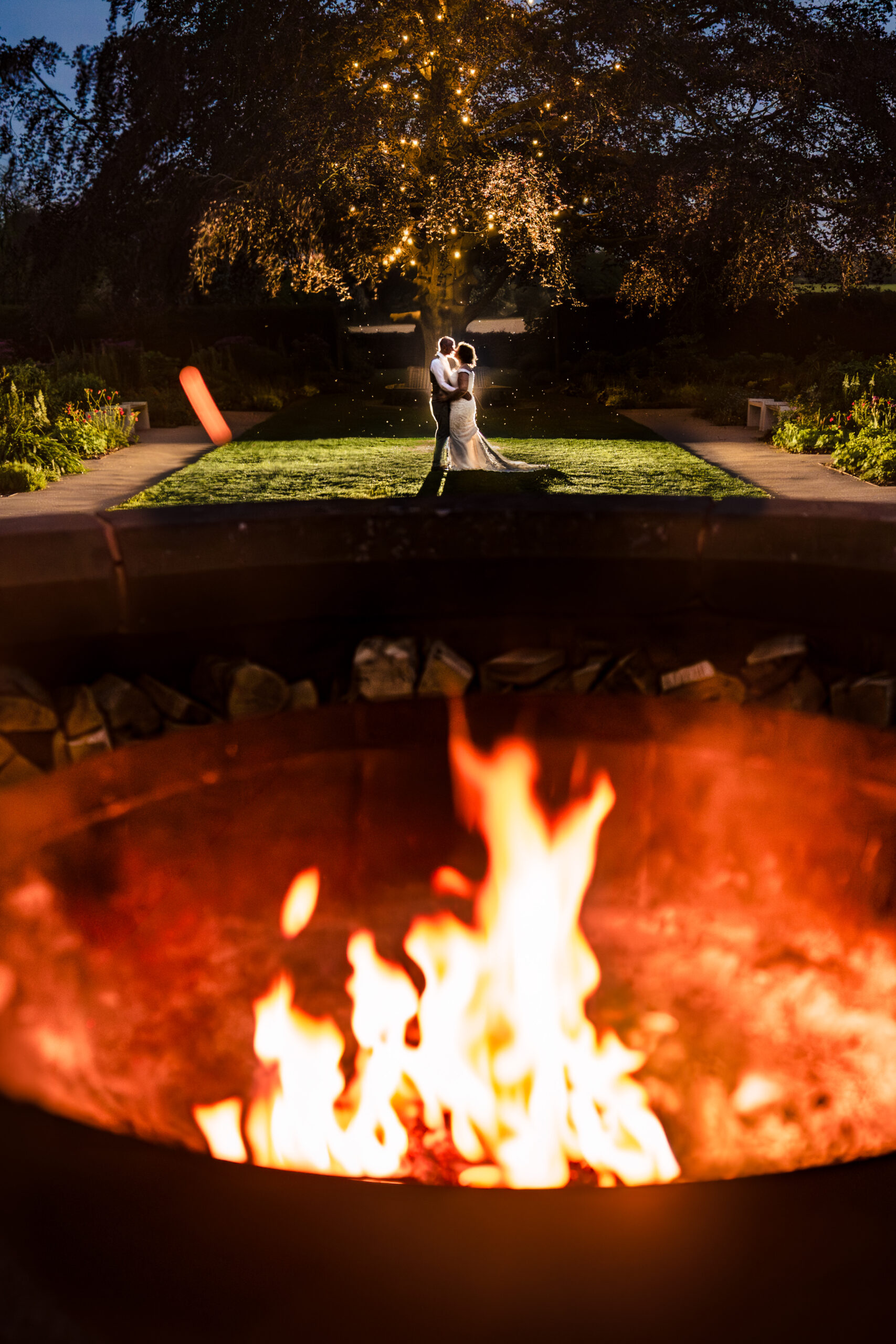 Flames from the outdoor fire pit at Salt House with guests dancing in the background