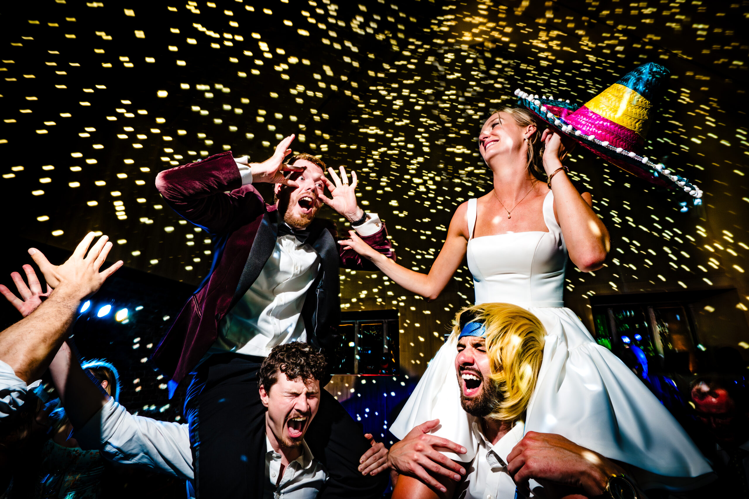 Bride lifted onto shoulders in a sombrero as the dance floor goes wild at Dorfold Hall, Cheshire wedding photographer