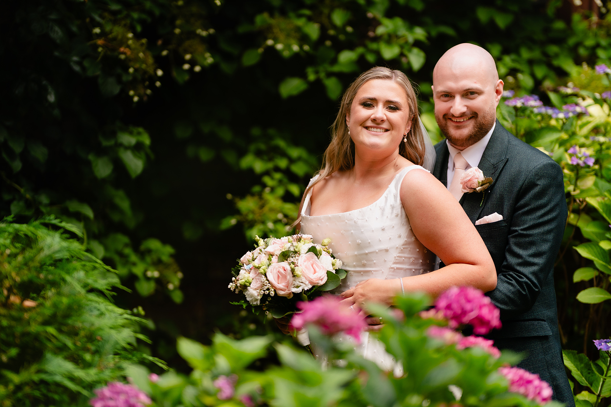 A quiet portrait of Chloe and Pete among the pink hydrangeas at Wrenbury Hall