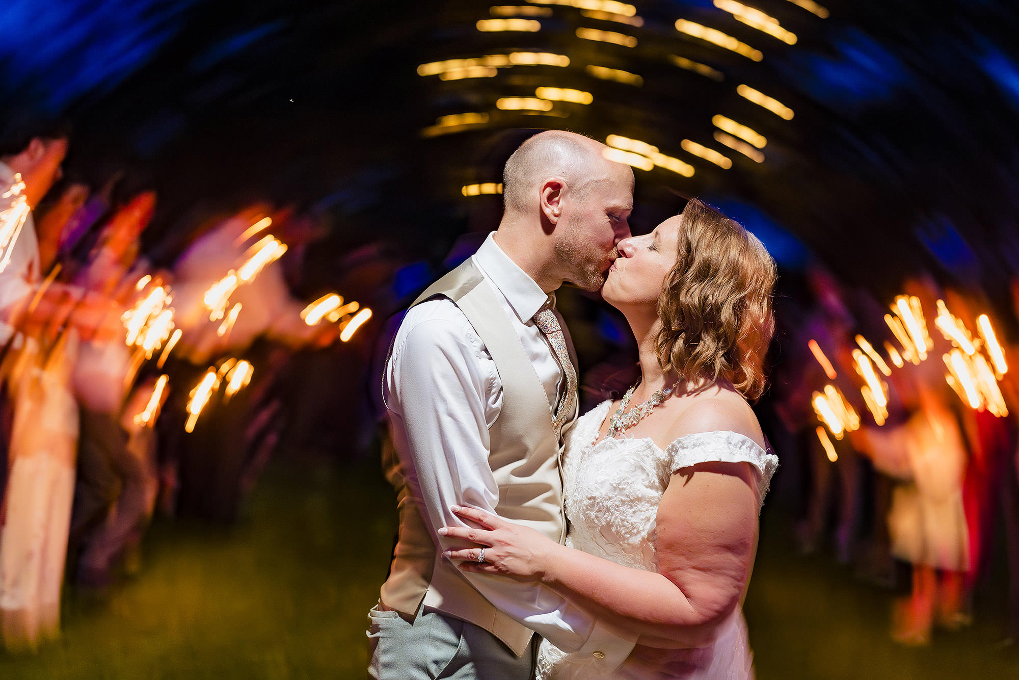 Artistic long exposure of the bride and groom kissing surrounded by sparkler light trails at Salt House