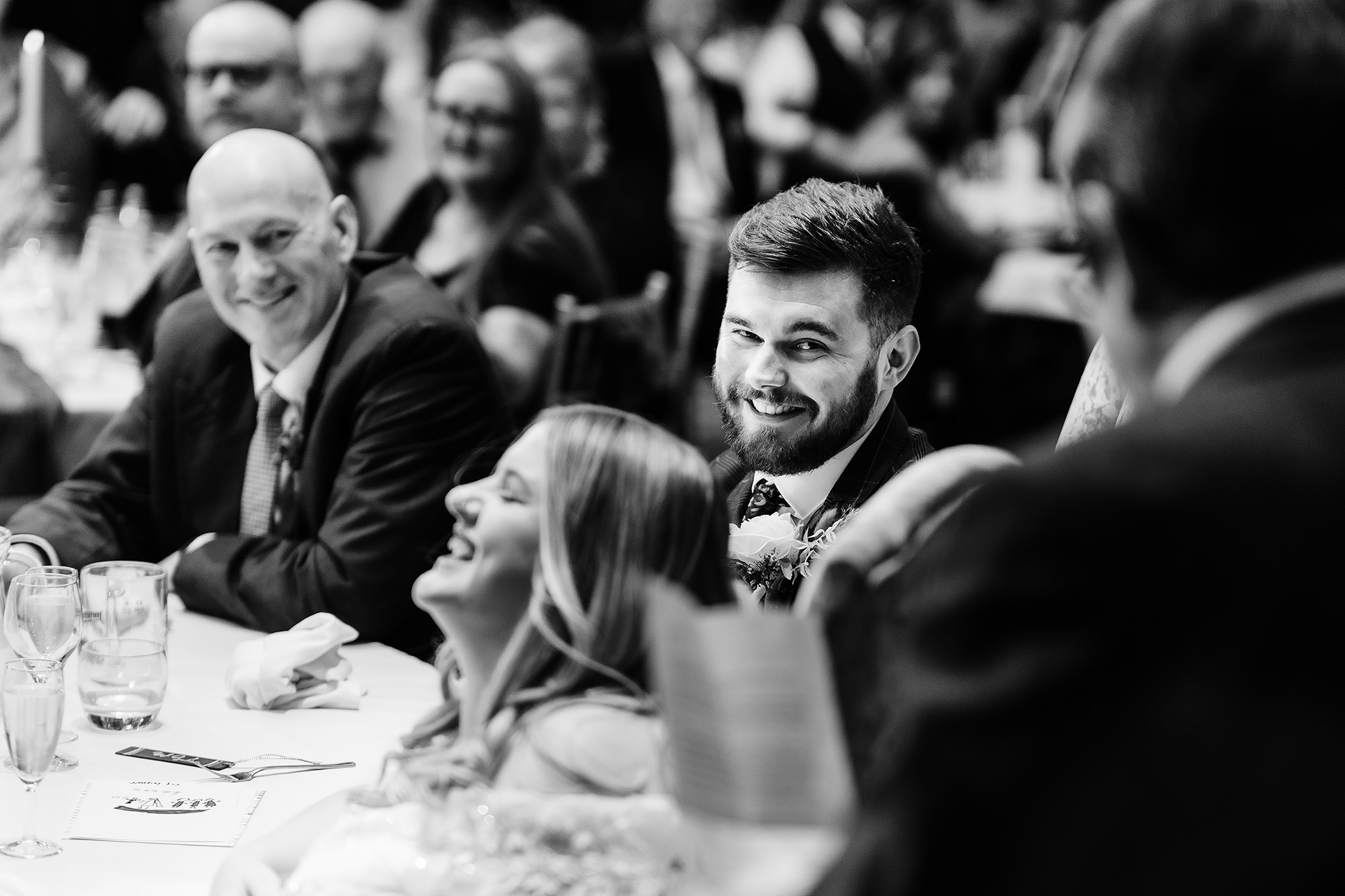Annie’s dad laughing with Tom and Annie during the speeches, Crewe Hall wedding photographer