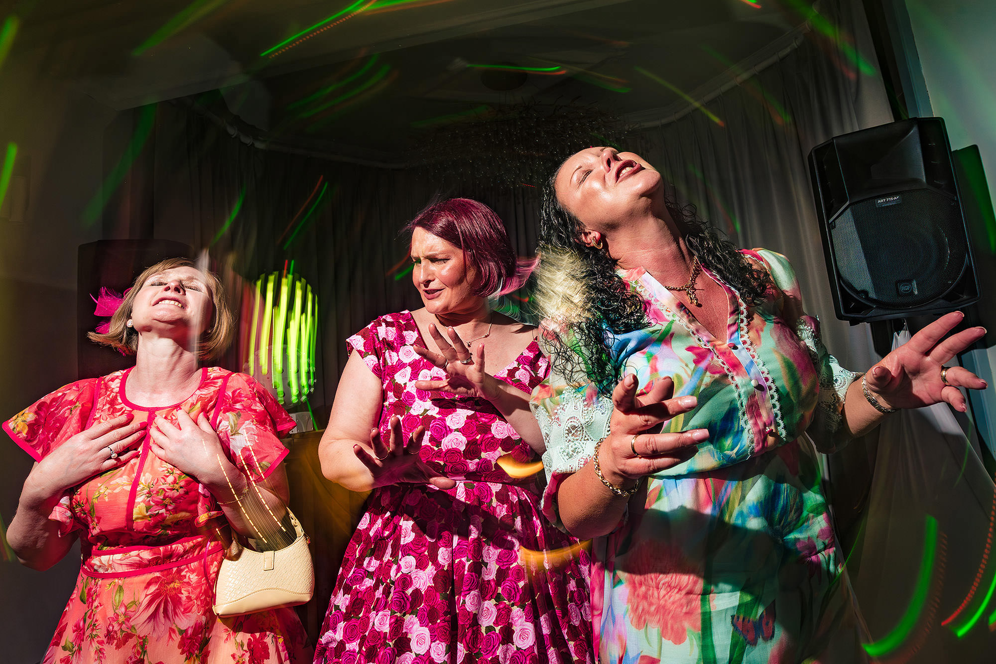 Wedding guests singing and dancing together indoors during the evening party at Salt House