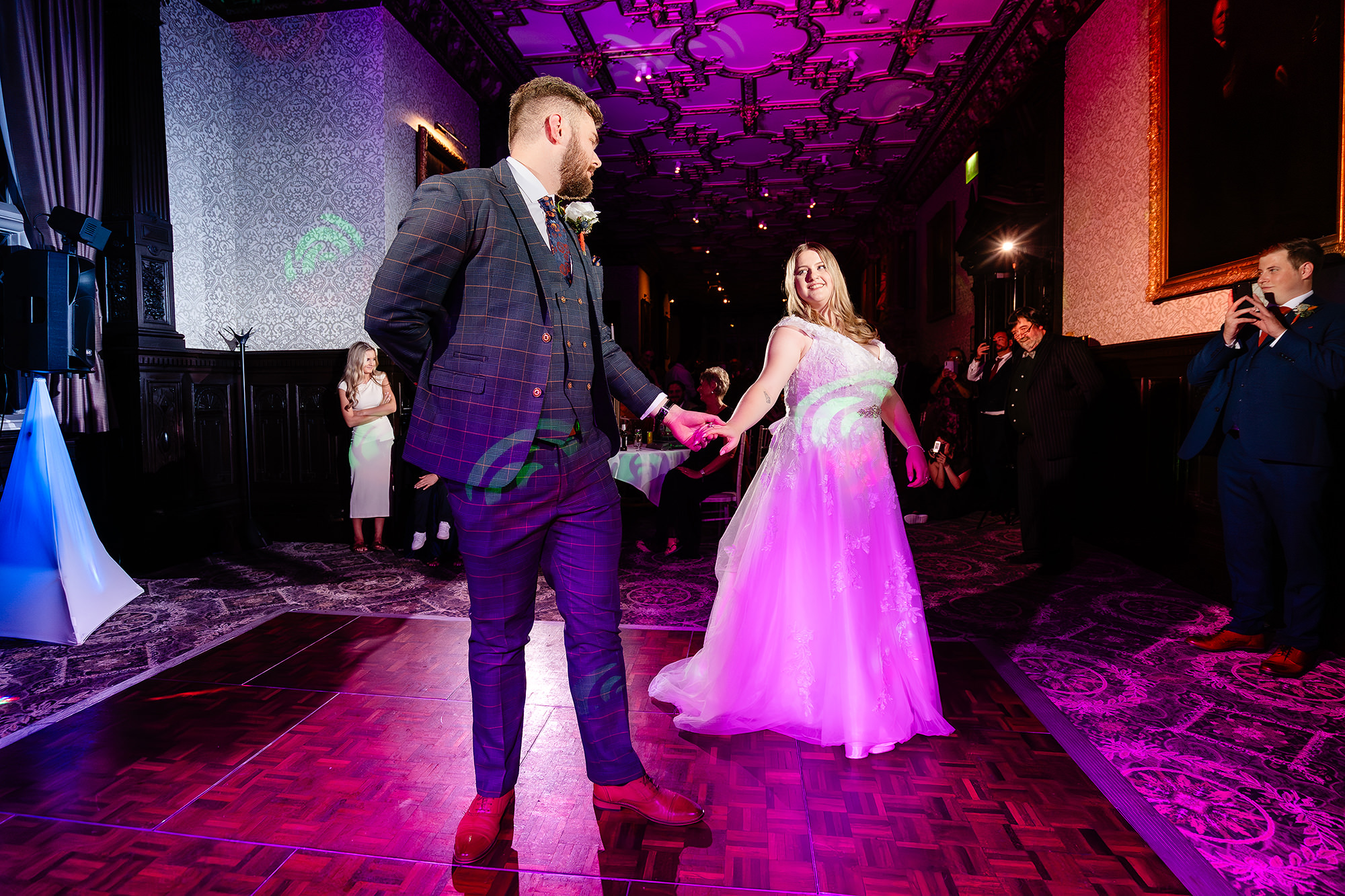 Annie and Tom starting their first dance under purple lighting at Crewe Hall, Cheshire wedding photographer