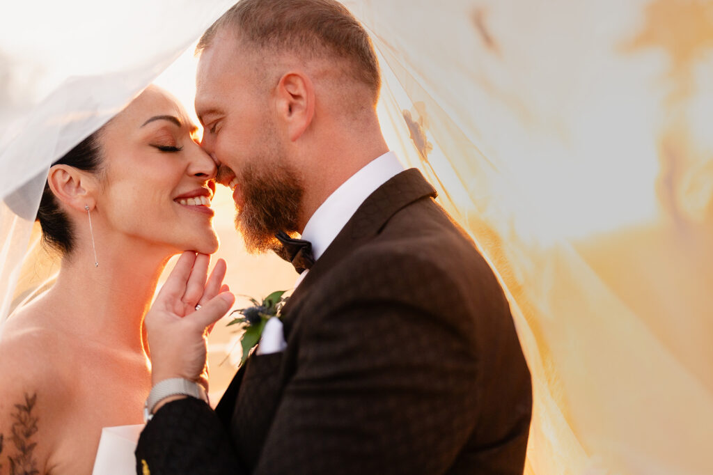 Kim and Glynn nose to nose under her veil in warm back light, Nottingham wedding photographer