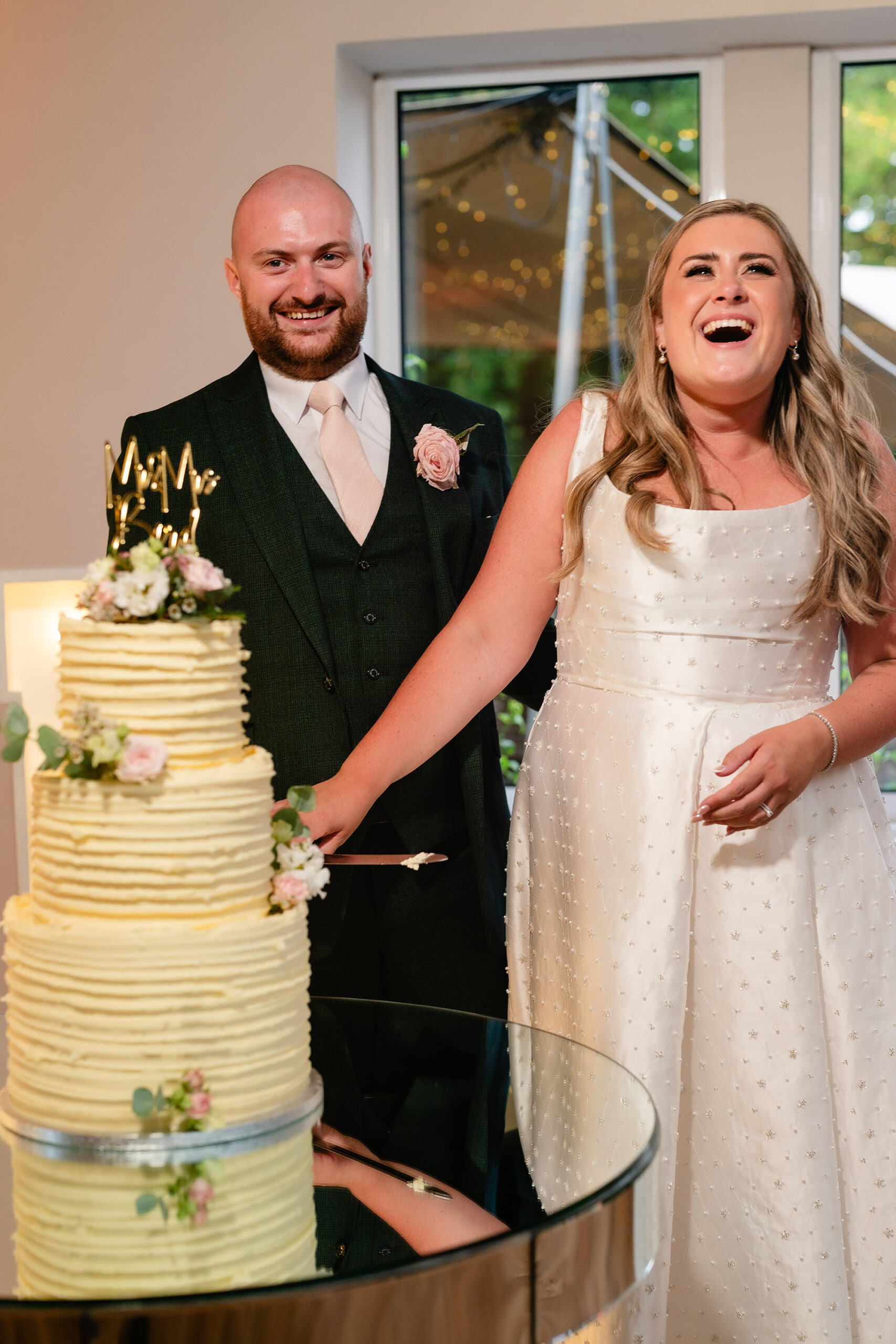 Chloe and Pete cutting their four tier semi naked wedding cake