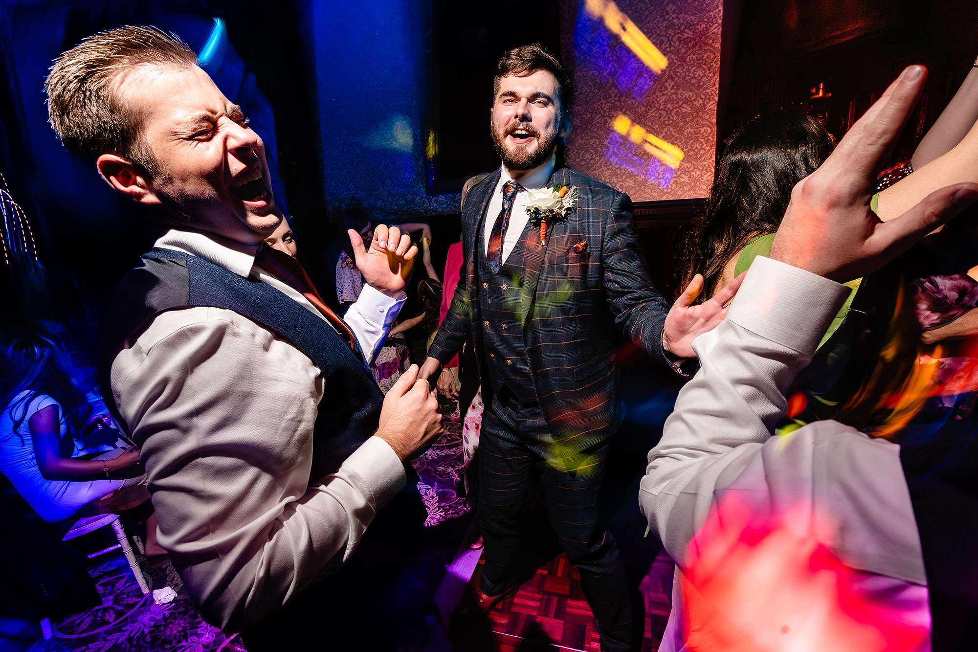Tom laughing and dancing with a friend on the dancefloor at Crewe Hall, Cheshire wedding photographer