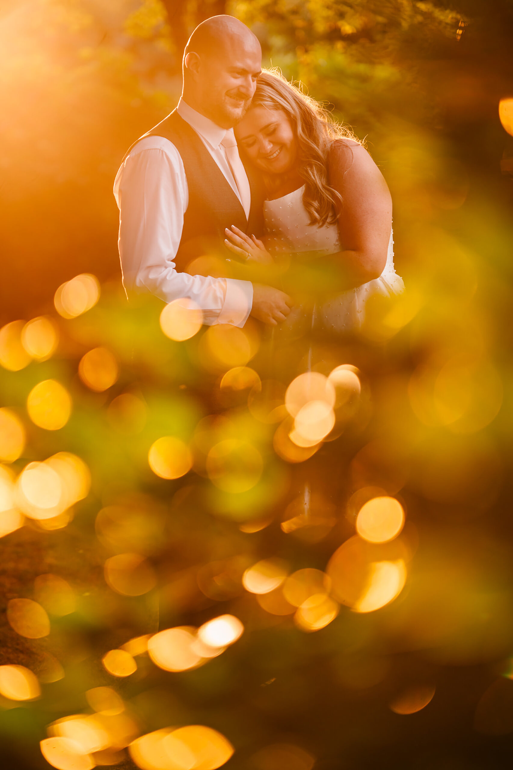 A close up golden hour portrait of Chloe and Pete through the leaves at Wrenbury Hall