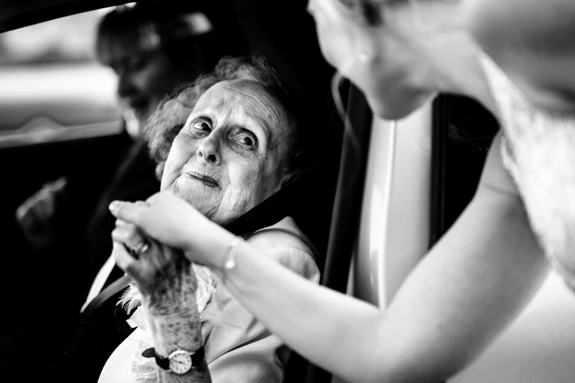 Black and white photograph of an emotional moment between the bride and an older guest
