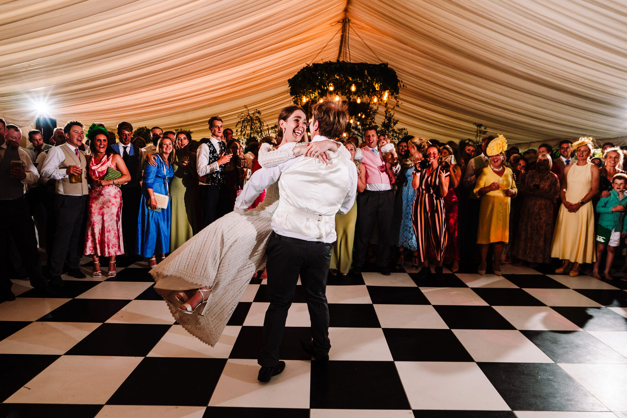 Bride and groom's first dance on a chequered floor in a marquee