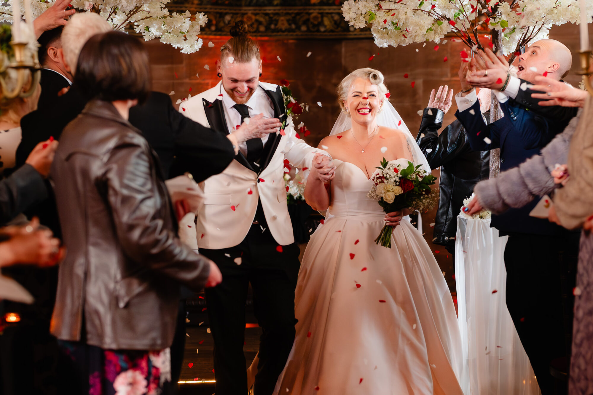Petals thrown over the newlyweds as they leave their ceremony at Peckforton Castle