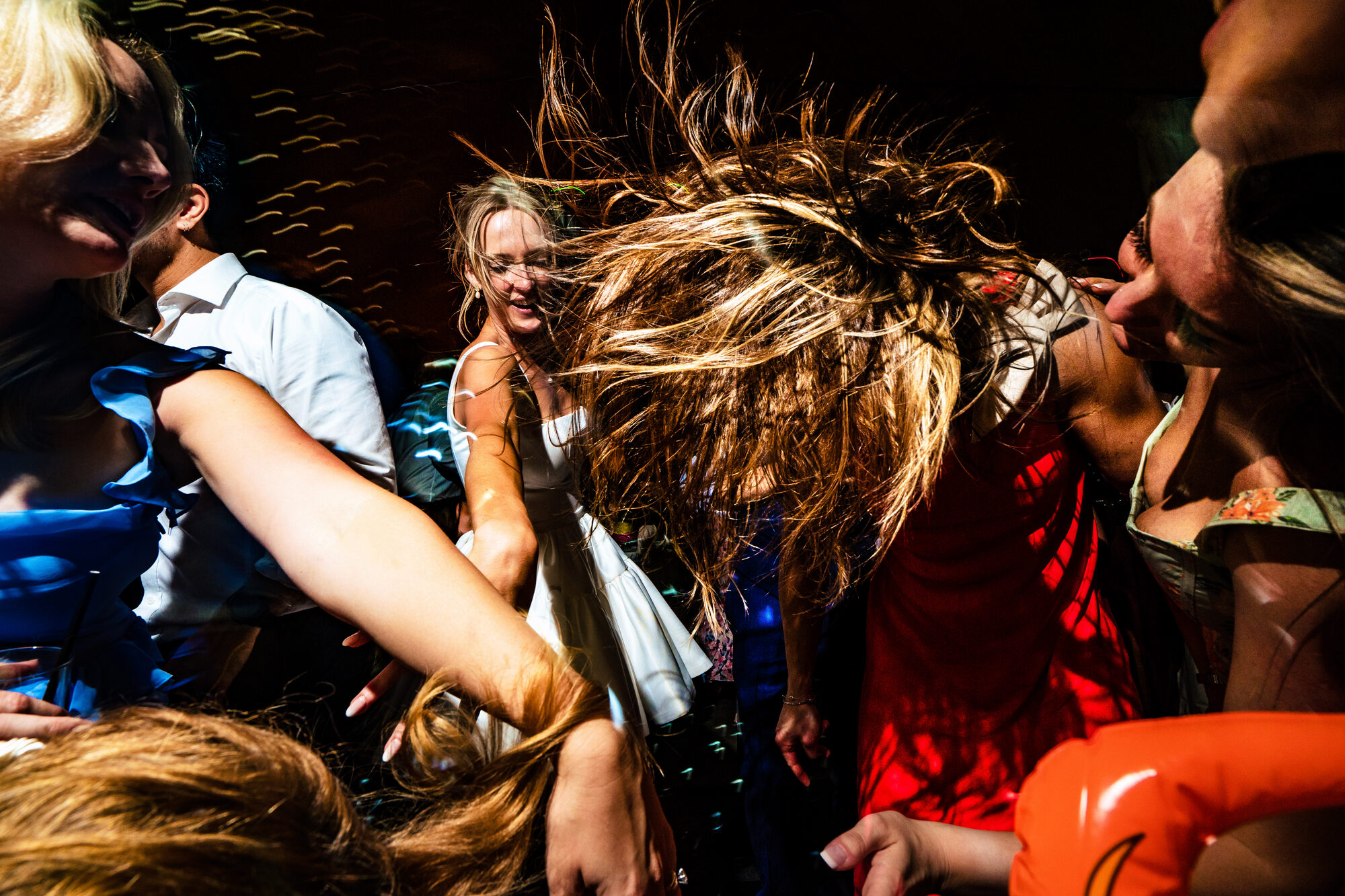 Guest dancing with her hair flying under the party lights