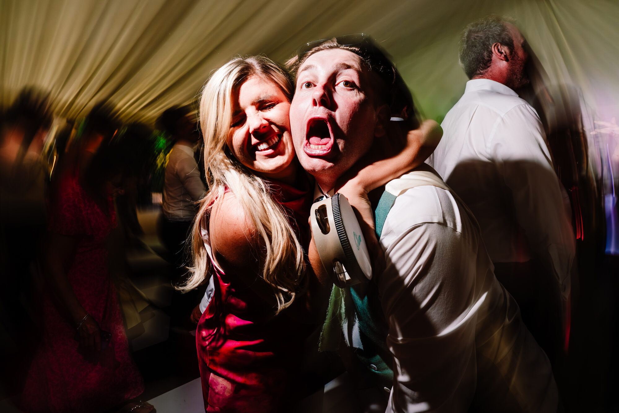 Two wedding guests screaming with laughter on the dance floor