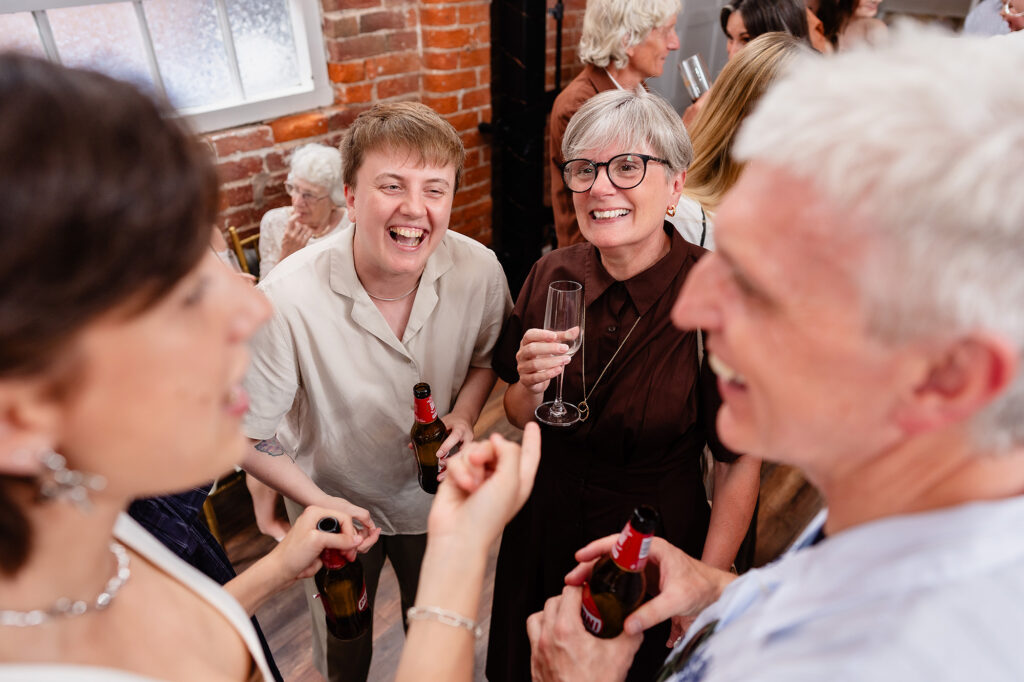 Guests laughing with drinks at The Hidden Barn @ 94 in Knutsford
