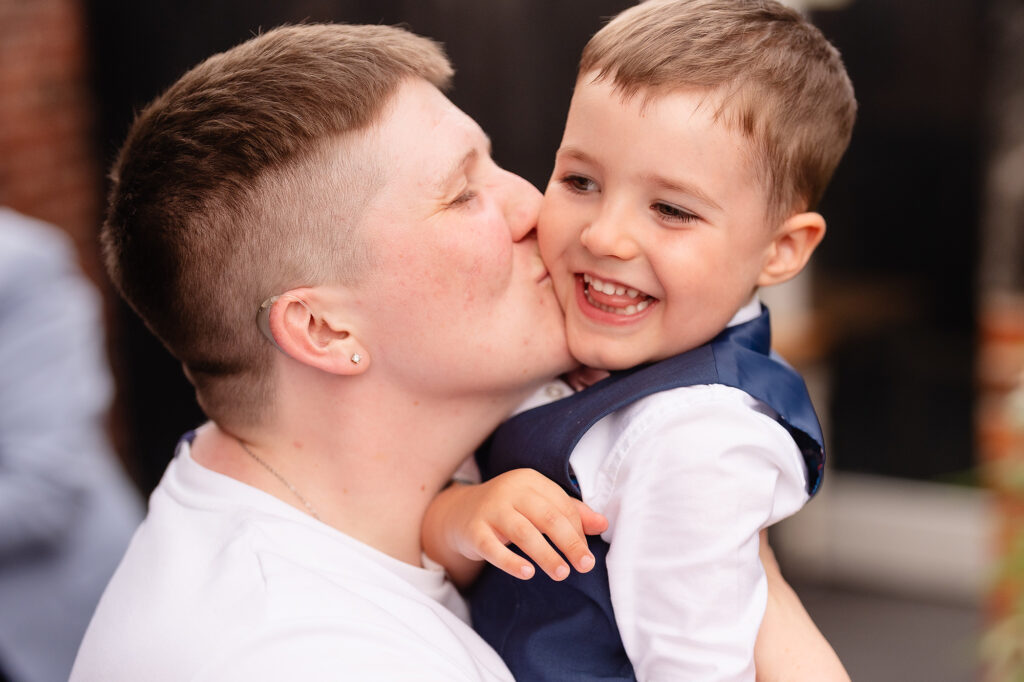 Marianne kissing a grinning little boy on the cheek