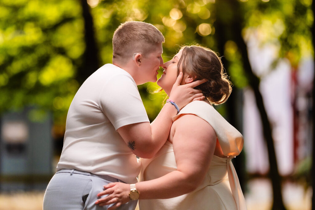 Marianne and Emma kissing in golden hour light
