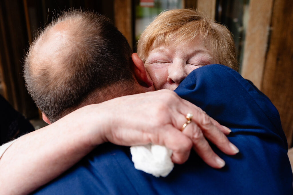 Guest with her eyes closed holding a tissue during an emotional hug