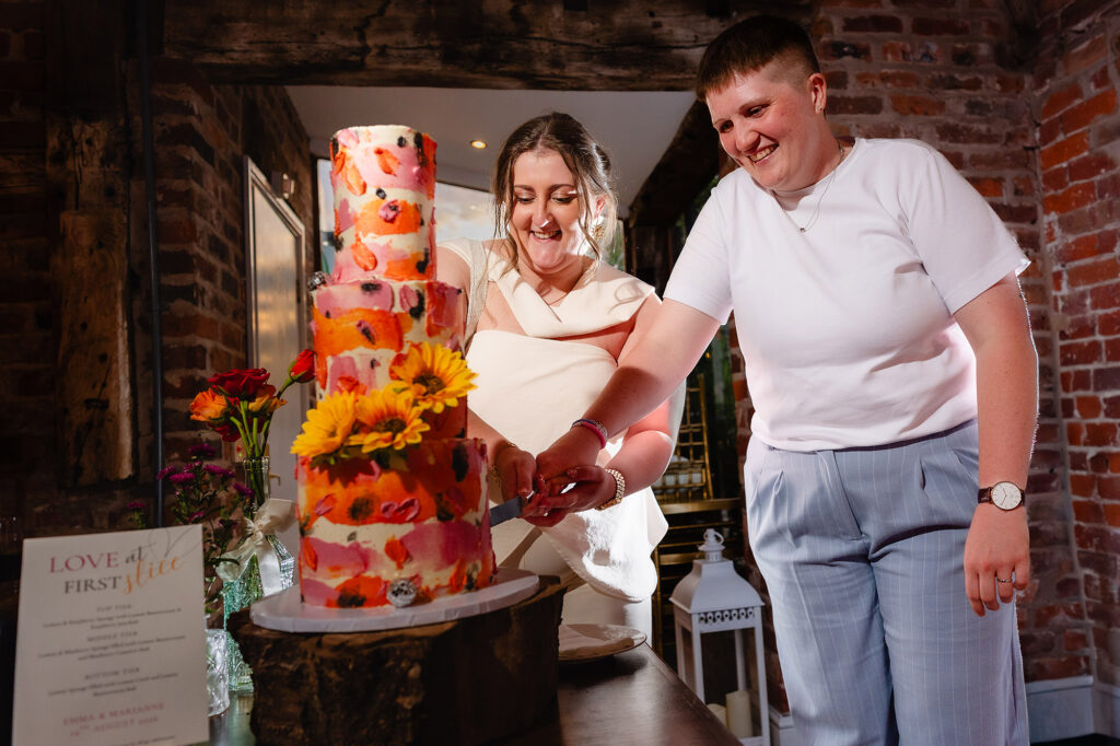 Marianne and Emma cutting their sunflower wedding cake, Knutsford wedding photographer
