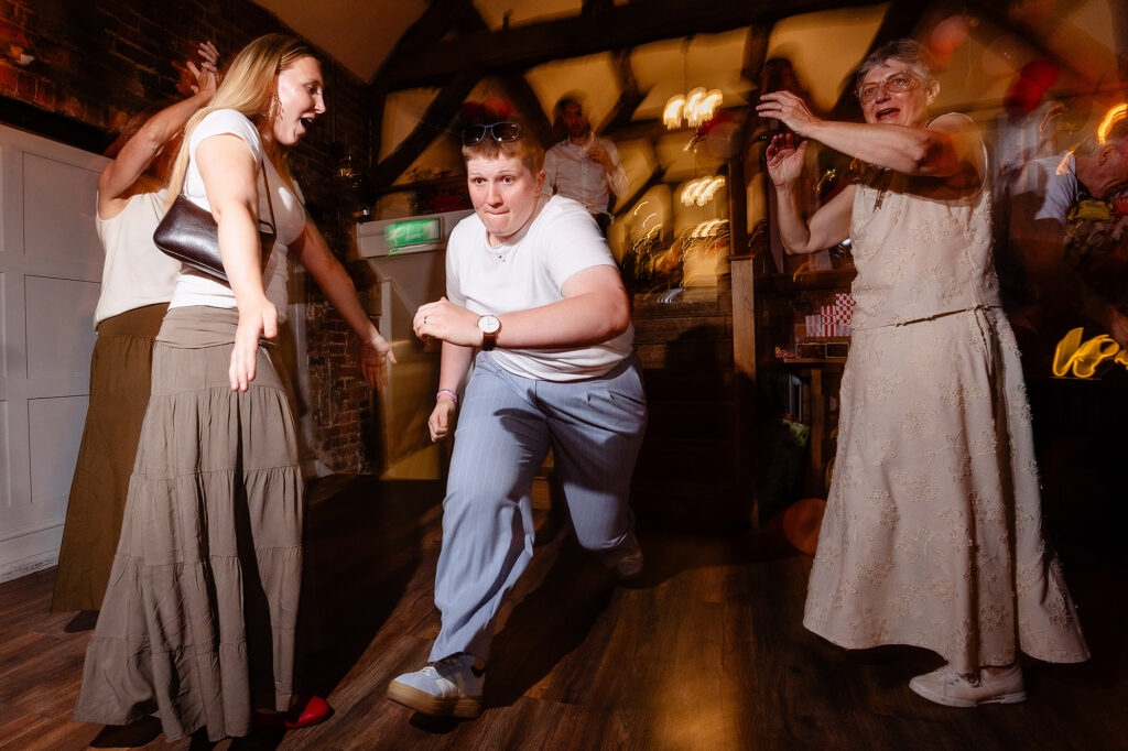 Marianne dancing low on the dance floor with guests around her