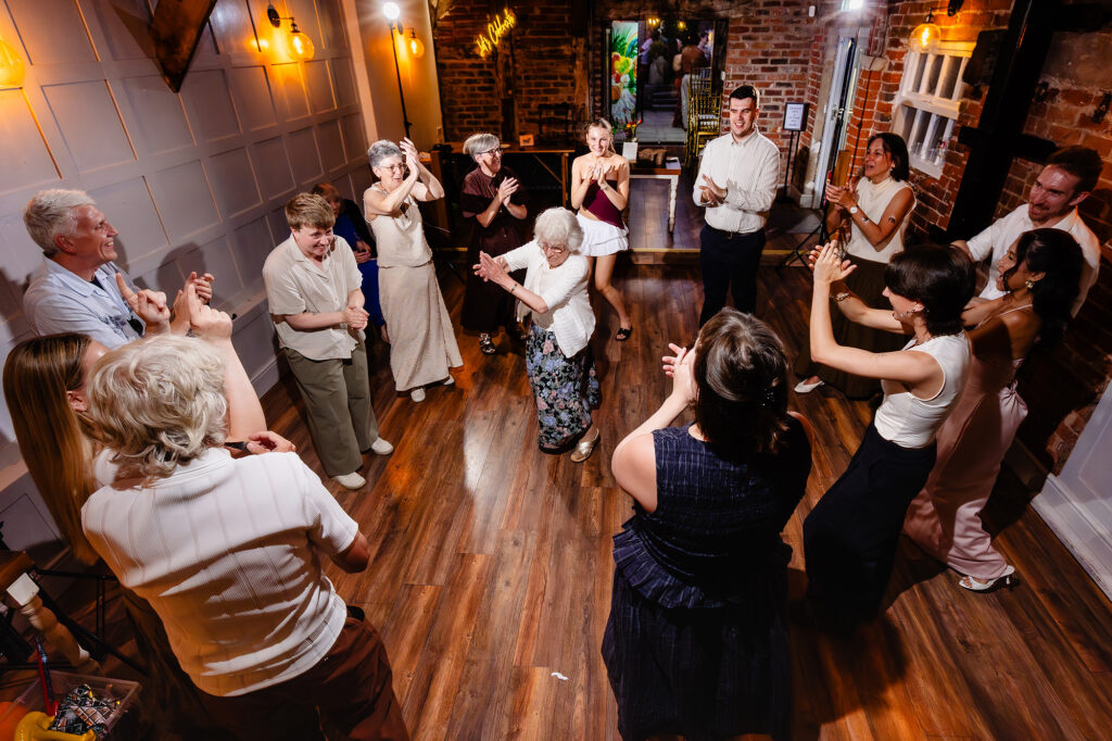 Grandma Gina dancing in the middle of a circle of clapping guests, Knutsford wedding photographer
