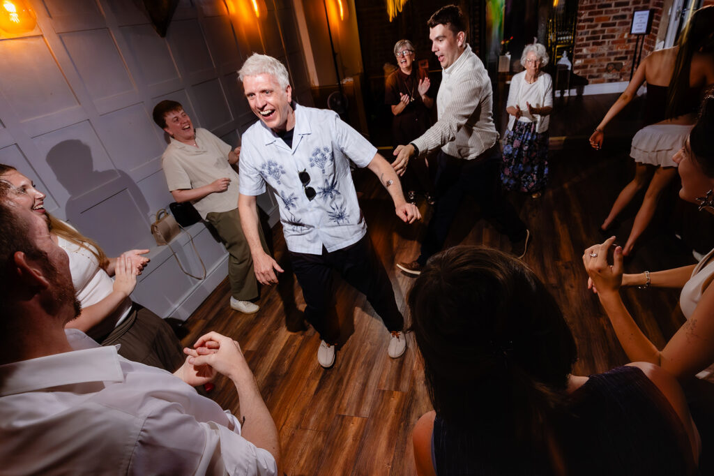 Guest in a printed shirt dancing as the crowd cheers him on